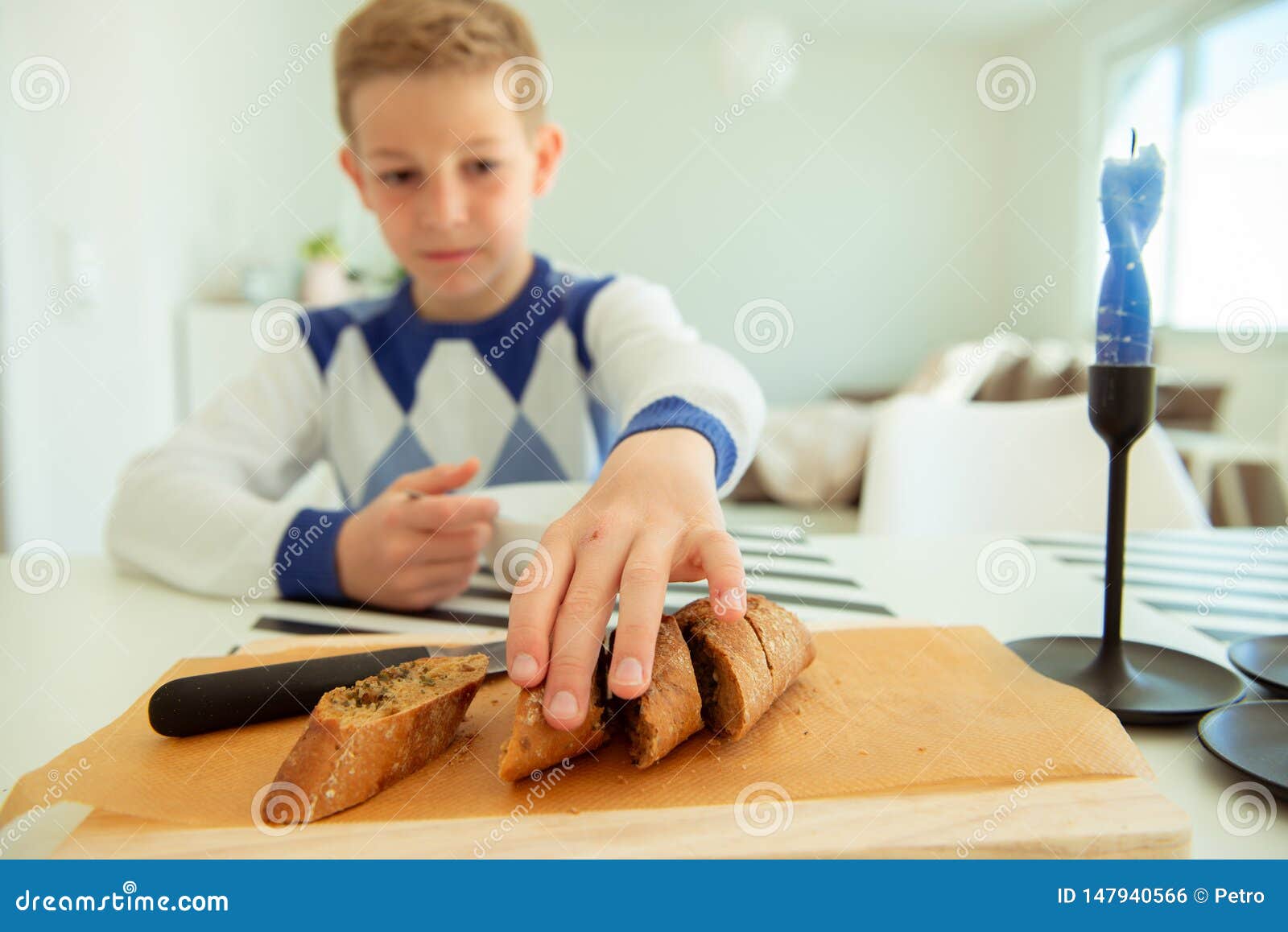 Handsome Teenager Eating Soup And Whole Grain Bread In Bright Li