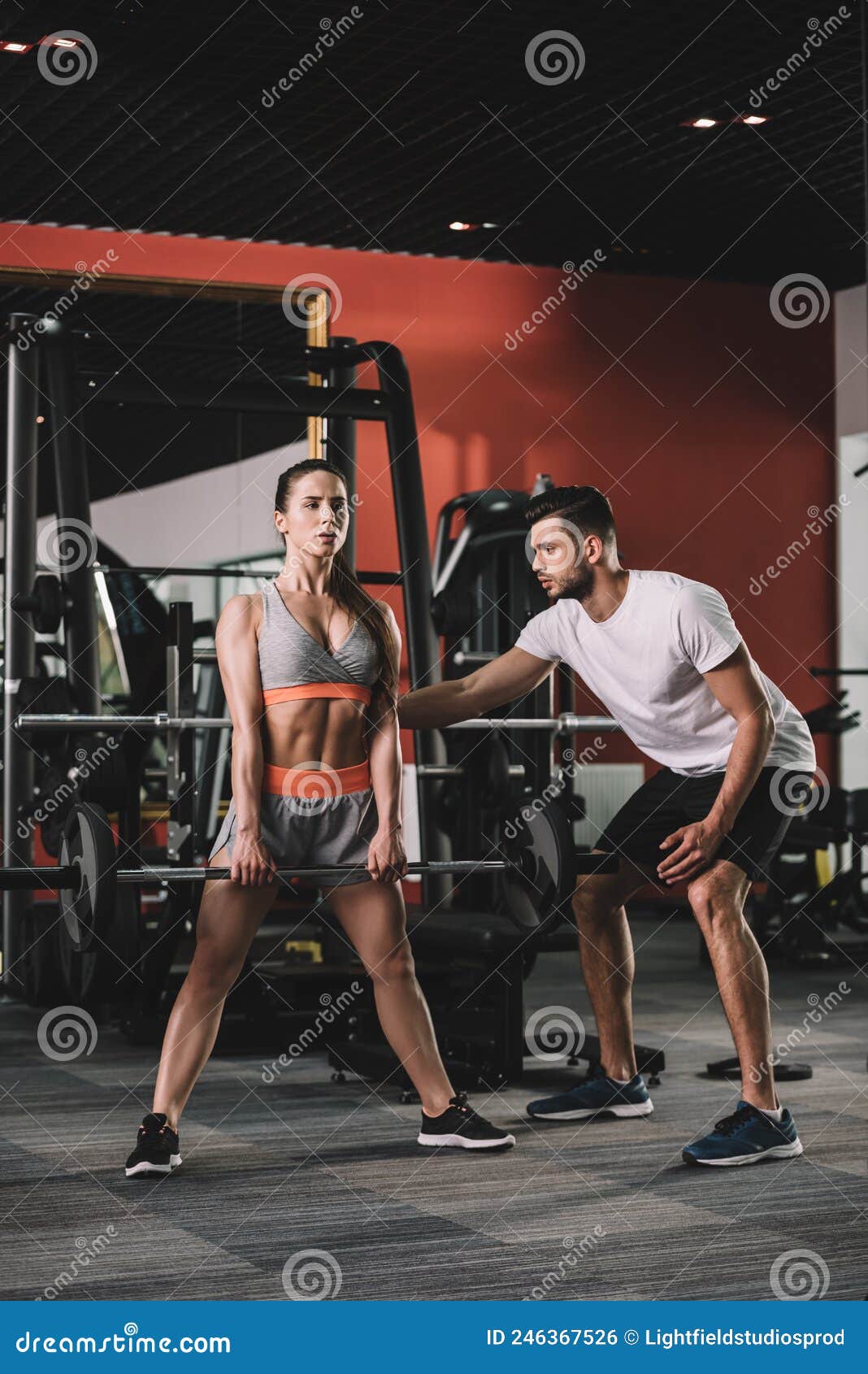 Handsome Trainer Supporting Attractive Sportswoman Lifting Stock Photo