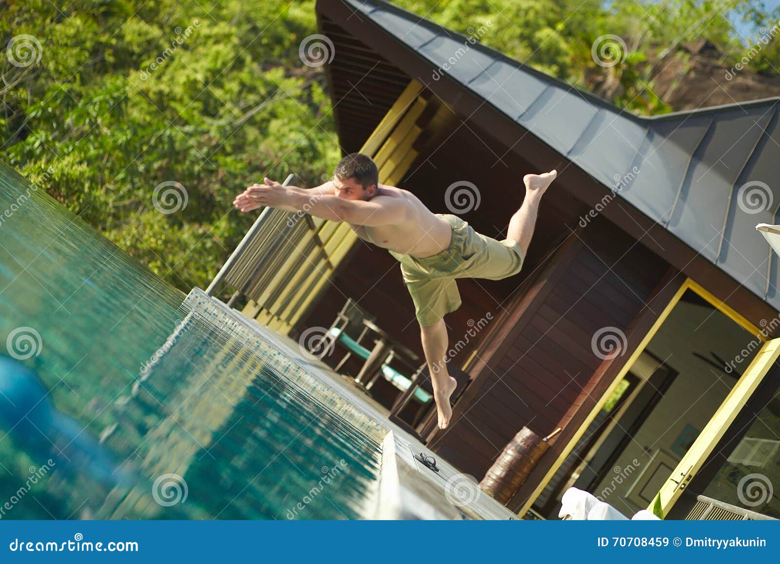 handsome young lifeguard plunge in swimming pool to rescue.