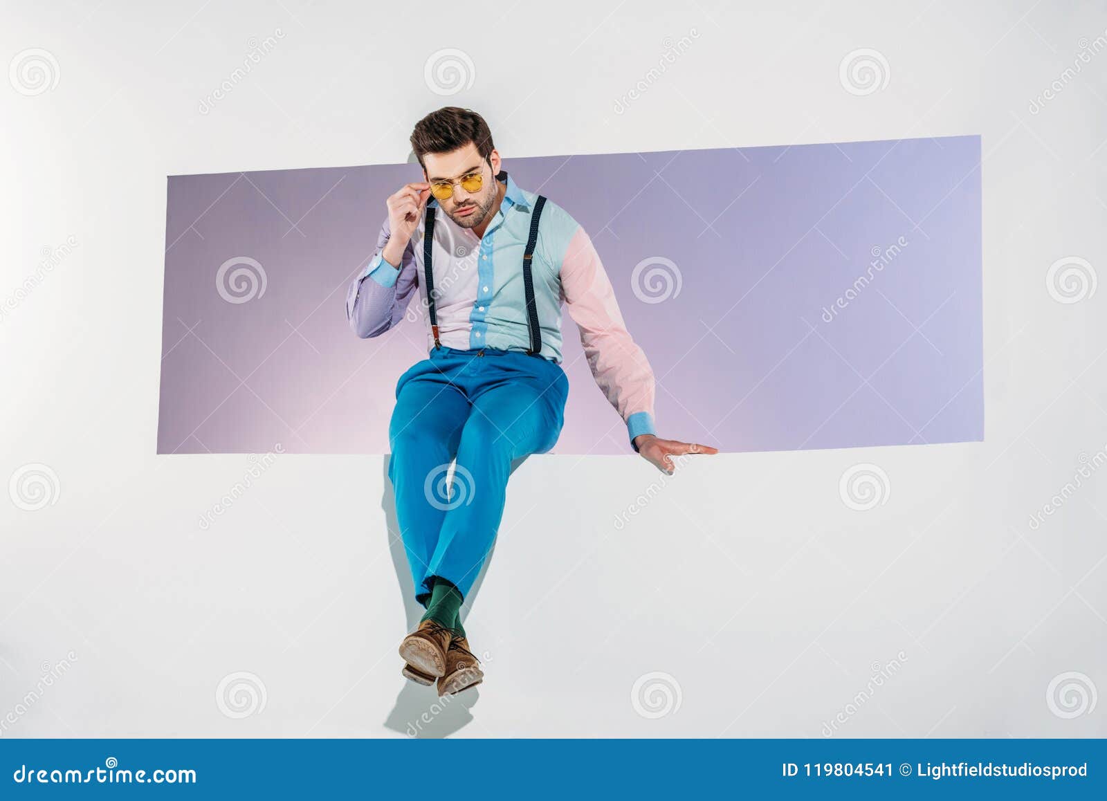 Handsome Young Man Adjusting Sunglasses while Sitting in Aperture Stock ...