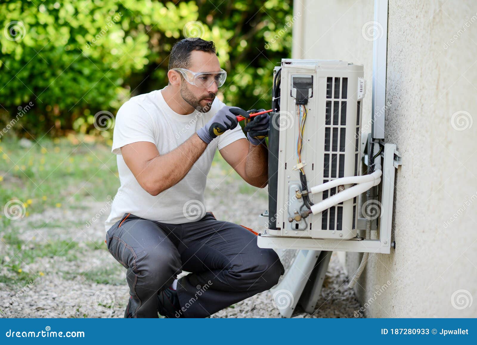 Handsome Young Man Electrician Installing Air Conditioning in a Client