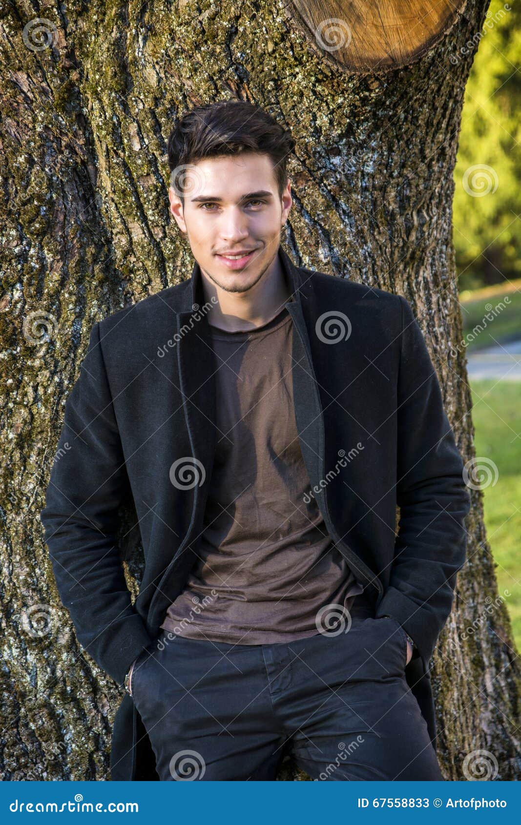 Handsome Young Man Leaning Against Tree Stock Image - Image of smiling ...