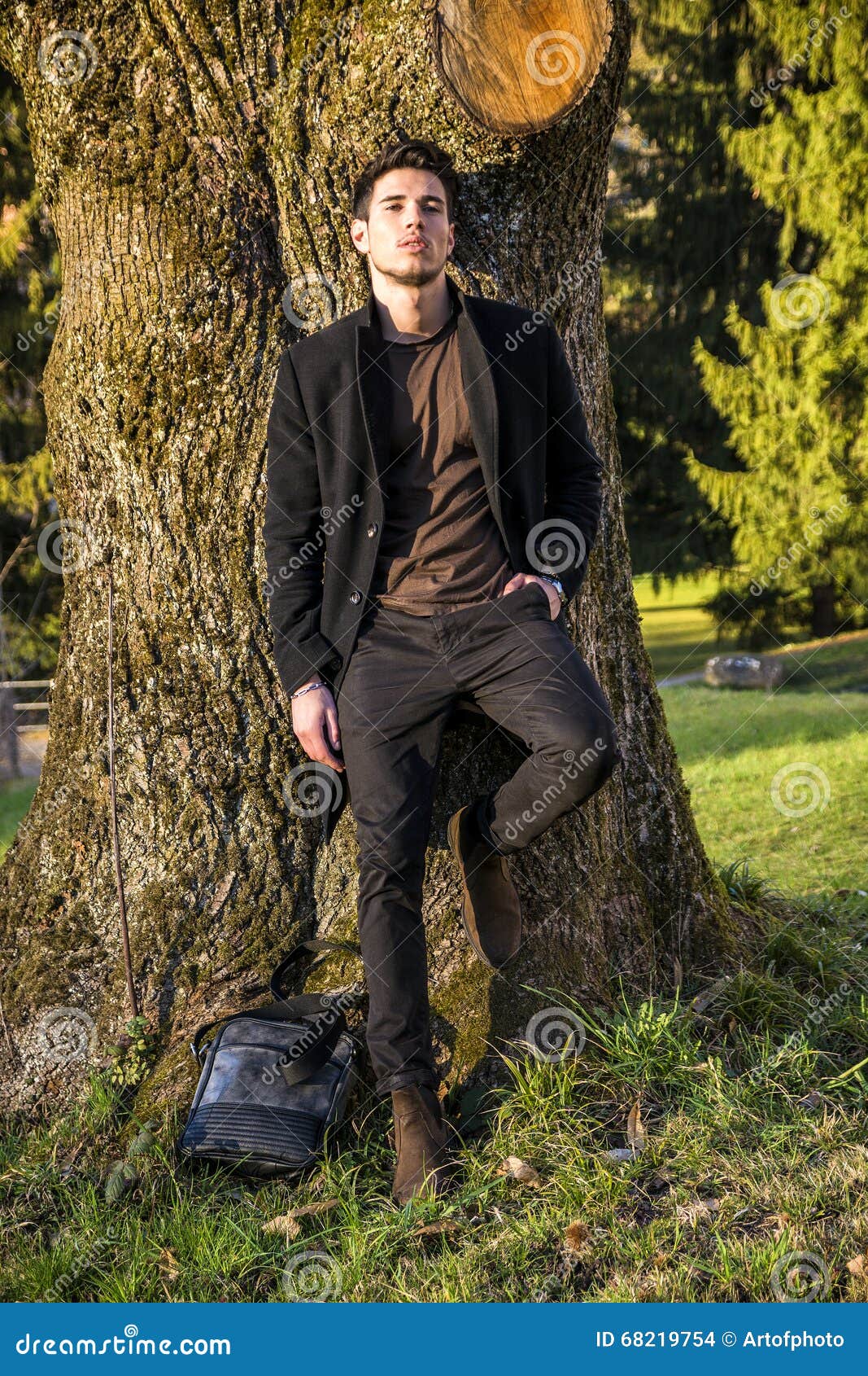 Handsome Young Man Leaning Against Tree Stock Photo - Image of body ...