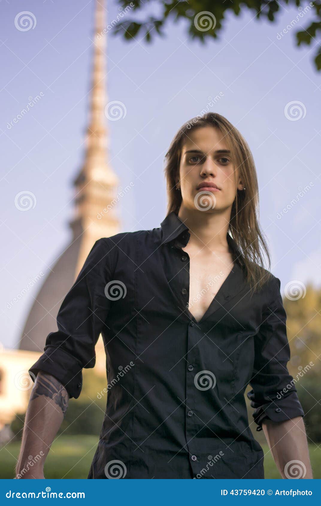 handsome young man next to mole antonelliana in turin, italy