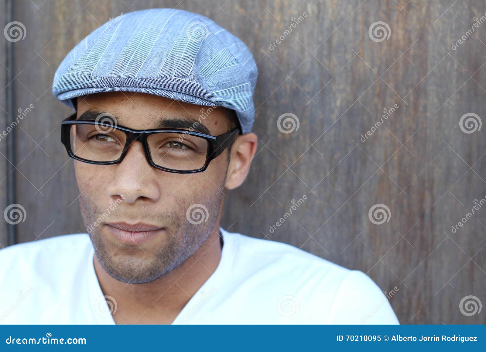 A Handsome Young Man in Plain Clothes Wearing Hat and Glasses Stock