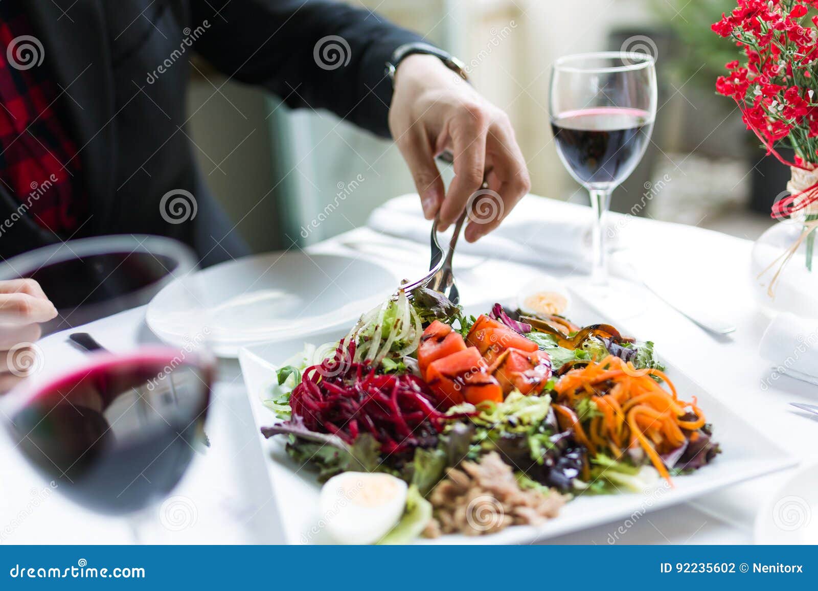 Handsome Young Man Serving Salad on a Plate in the Restaurant. Stock