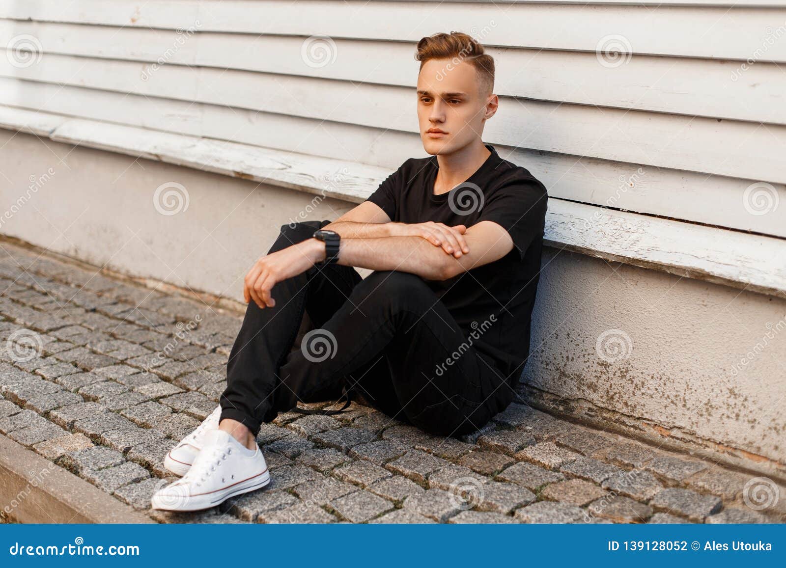 Handsome Young Man with a Stylish Hairstyle in Stylish Black Summer Clothes in Fashionable White Sneakers Sits Stock Photo - Image of lifestyle, background: 139128052 Handsome Young Man with a Stylish Hairstyle in Stylish Black Summer Clothes in Fashionable White Sneakers Sits Stock Photo - Image of lifestyle, background: 139128052