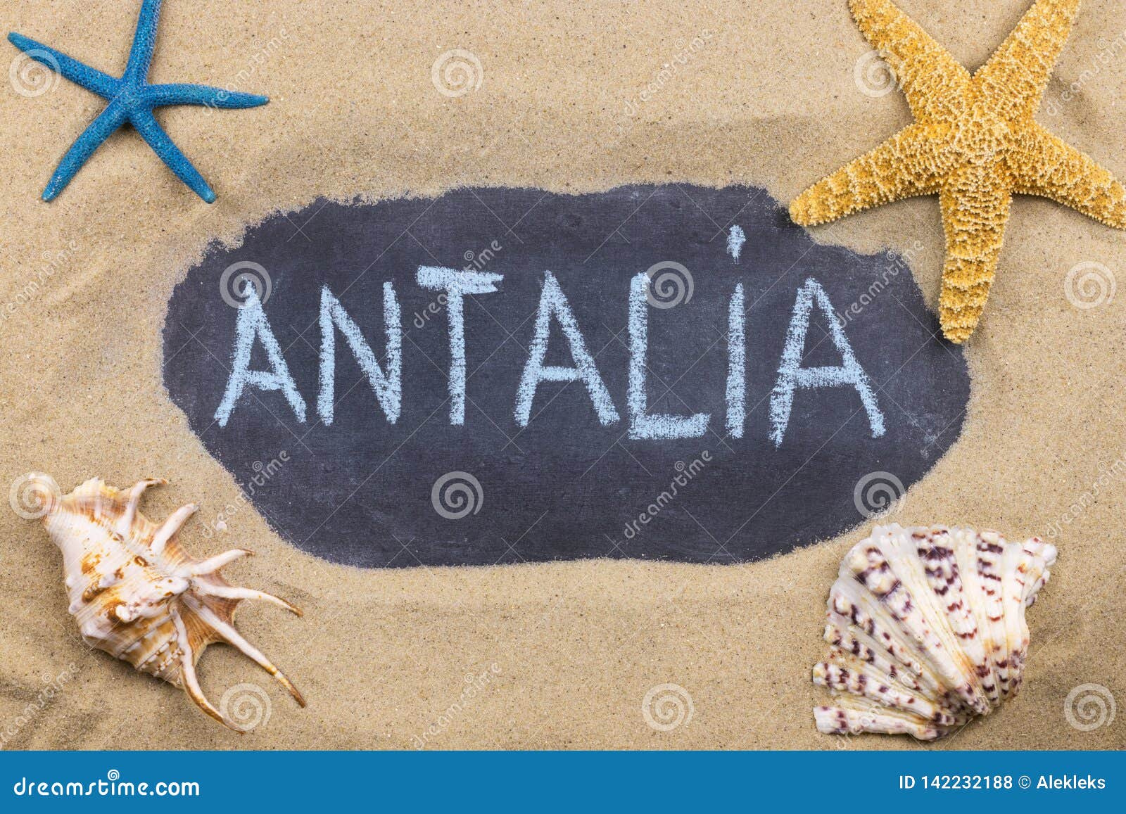 handwritten word antalia written in chalk, among seashells and starfishes