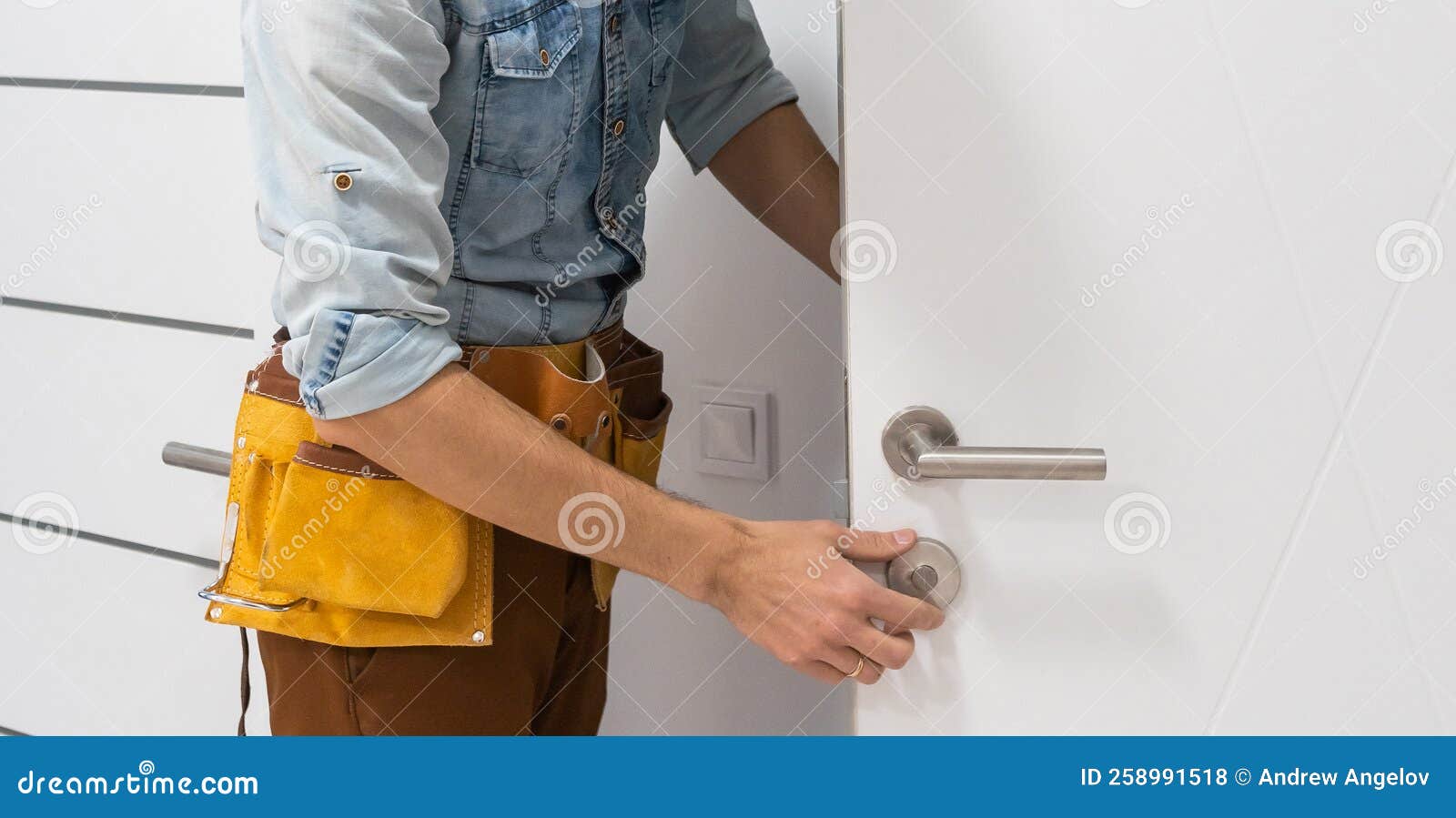 Handyman Fitting a New Door Using a Screwdriver at Home Stock Photo