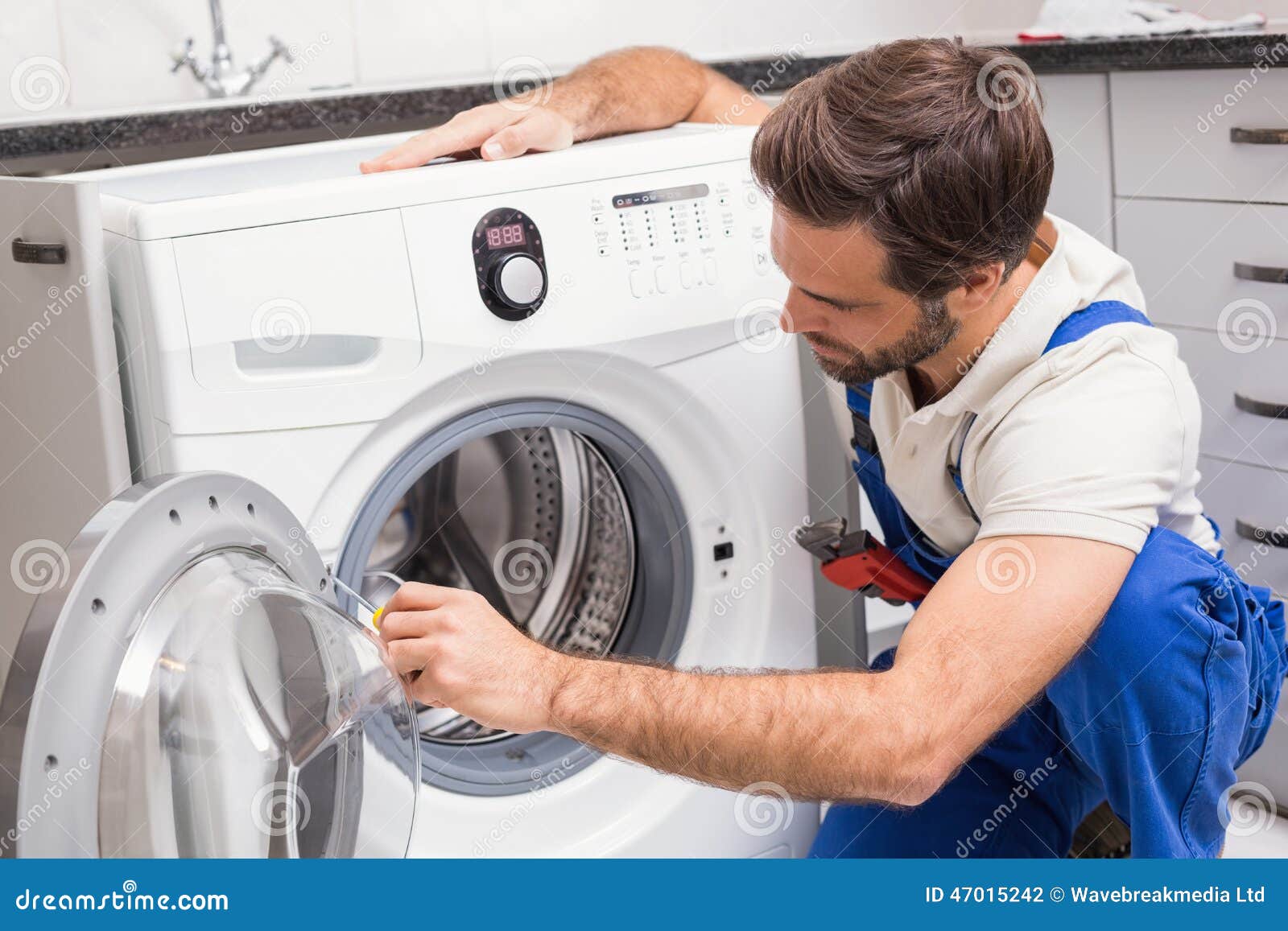 handyman-fixing-washing-machine-kitchen-47015242.jpg