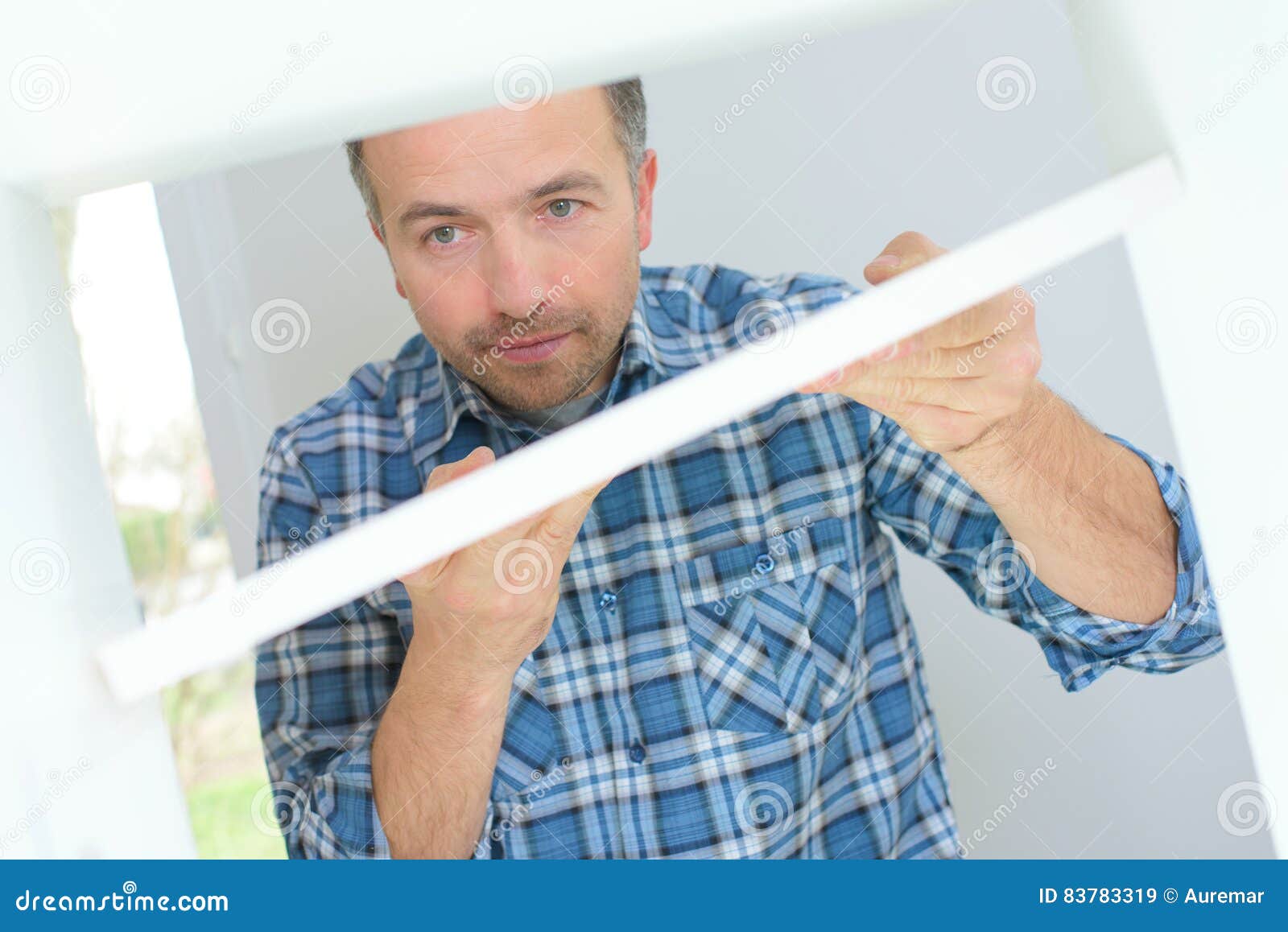 Handyman putting up shelf stock image. Image of building 83783319