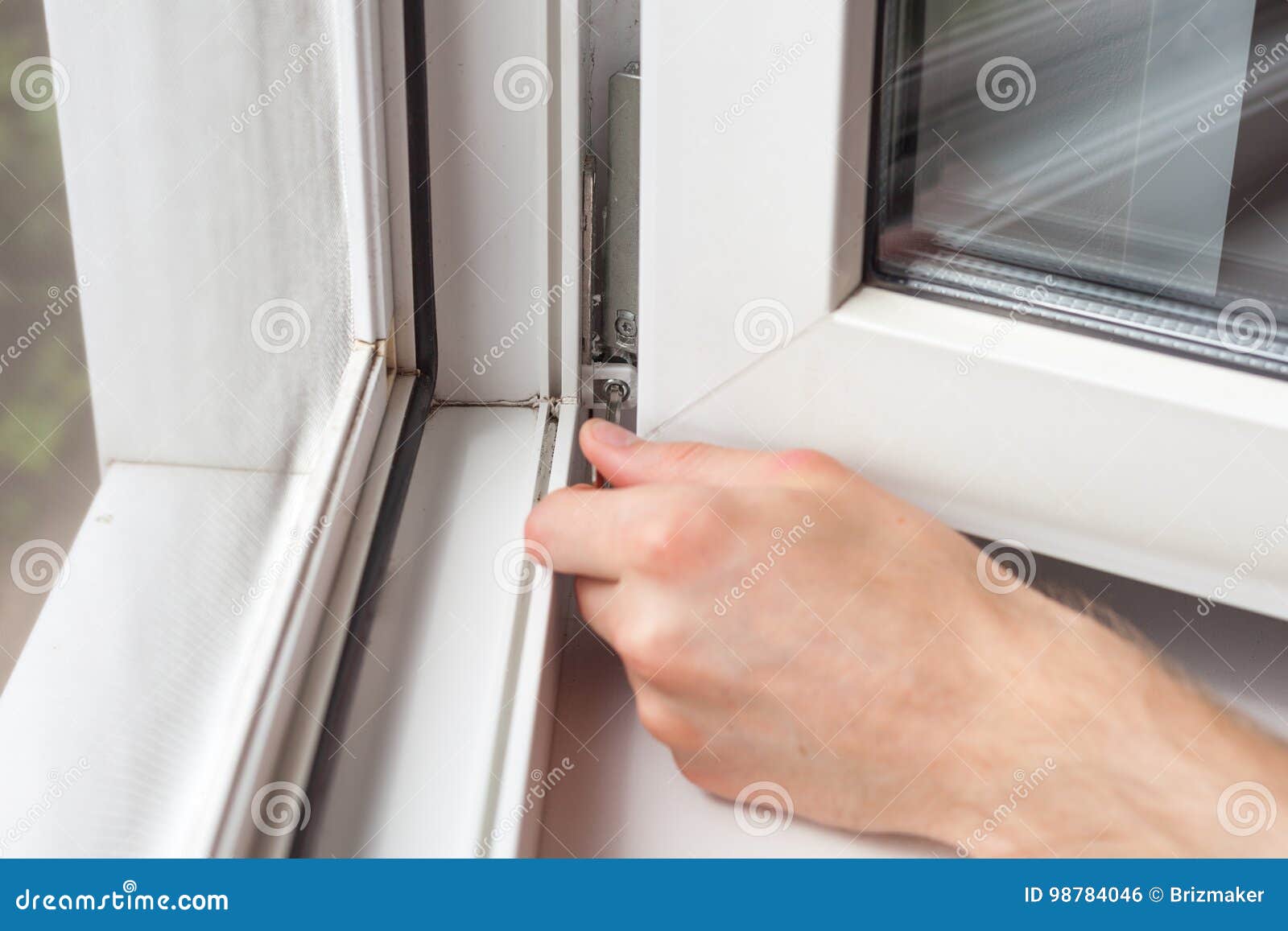 Handyman Repairs Plastic Window with a Hexagon. Workman Adjusts the