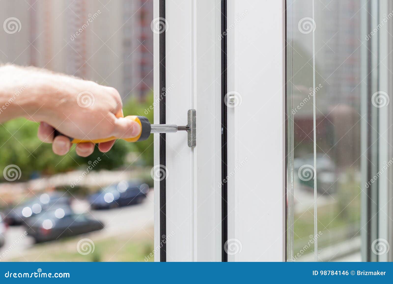 Handyman Repairs Plastic Window with Screwdriver. Workman Adjusts the