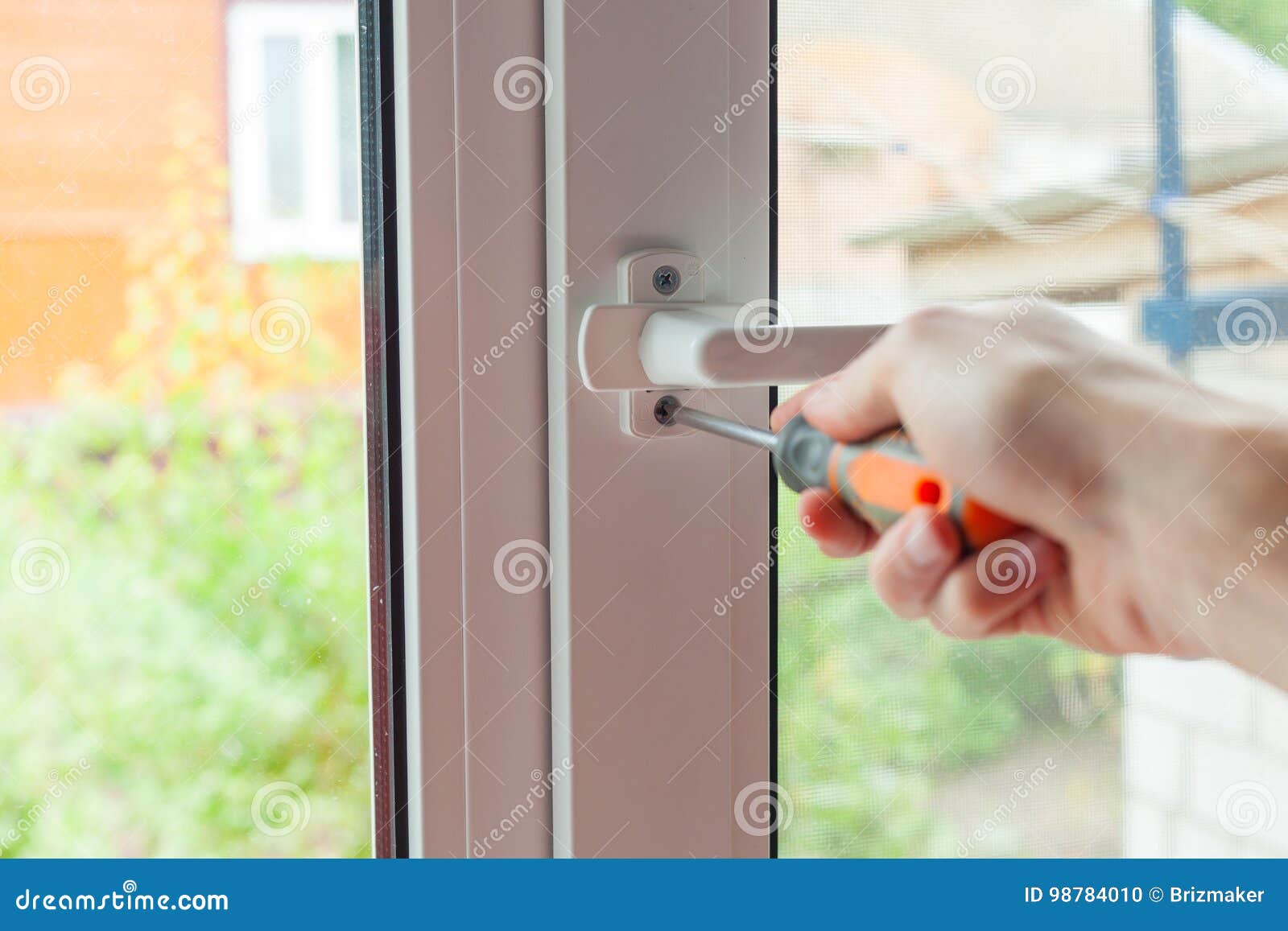 Handyman Repairs Plastic Window with Screwdriver. Workman Adjusts the
