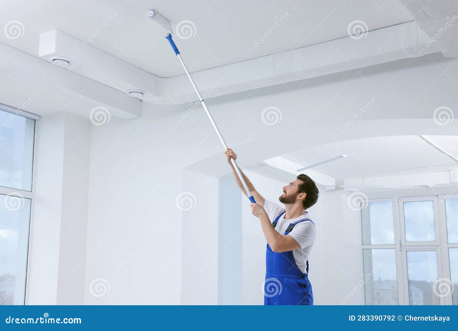 Handyman with Roller Painting Ceiling in Room Stock Photo Image of