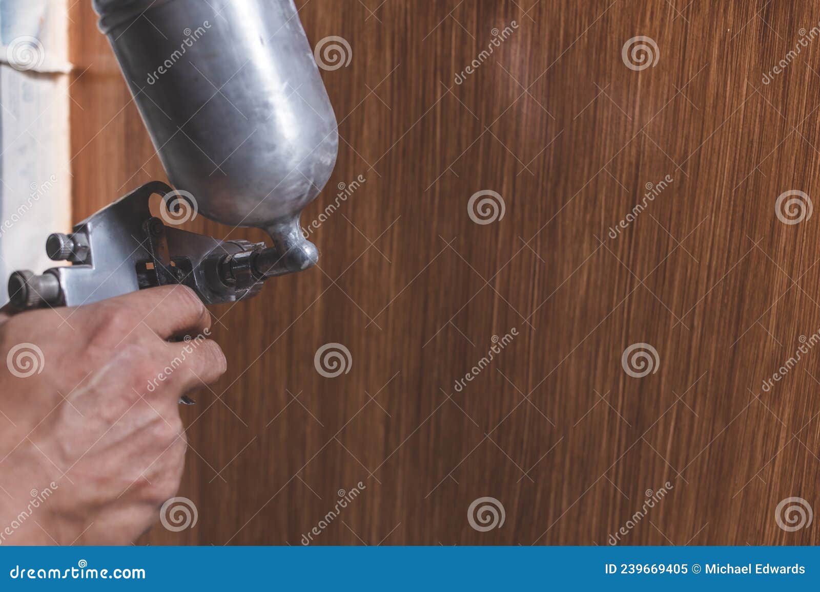 A Handyman Sprays Lacquer Wood Finish To the End Panel of the Bottom