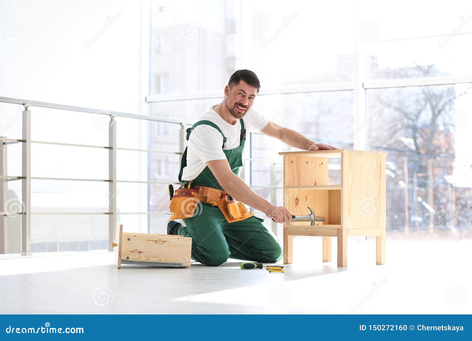 Handyman in Uniform Assembling Furniture. Professional Construction