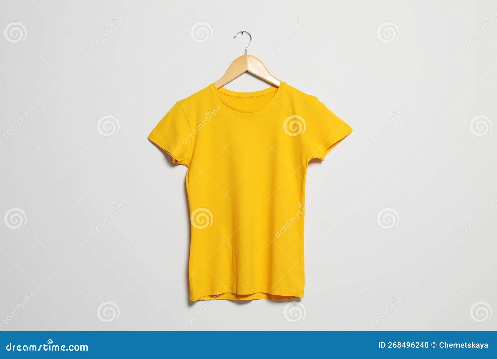 Hanger with Yellow Tshirt on Light Wall. Mockup for Design Stock Photo