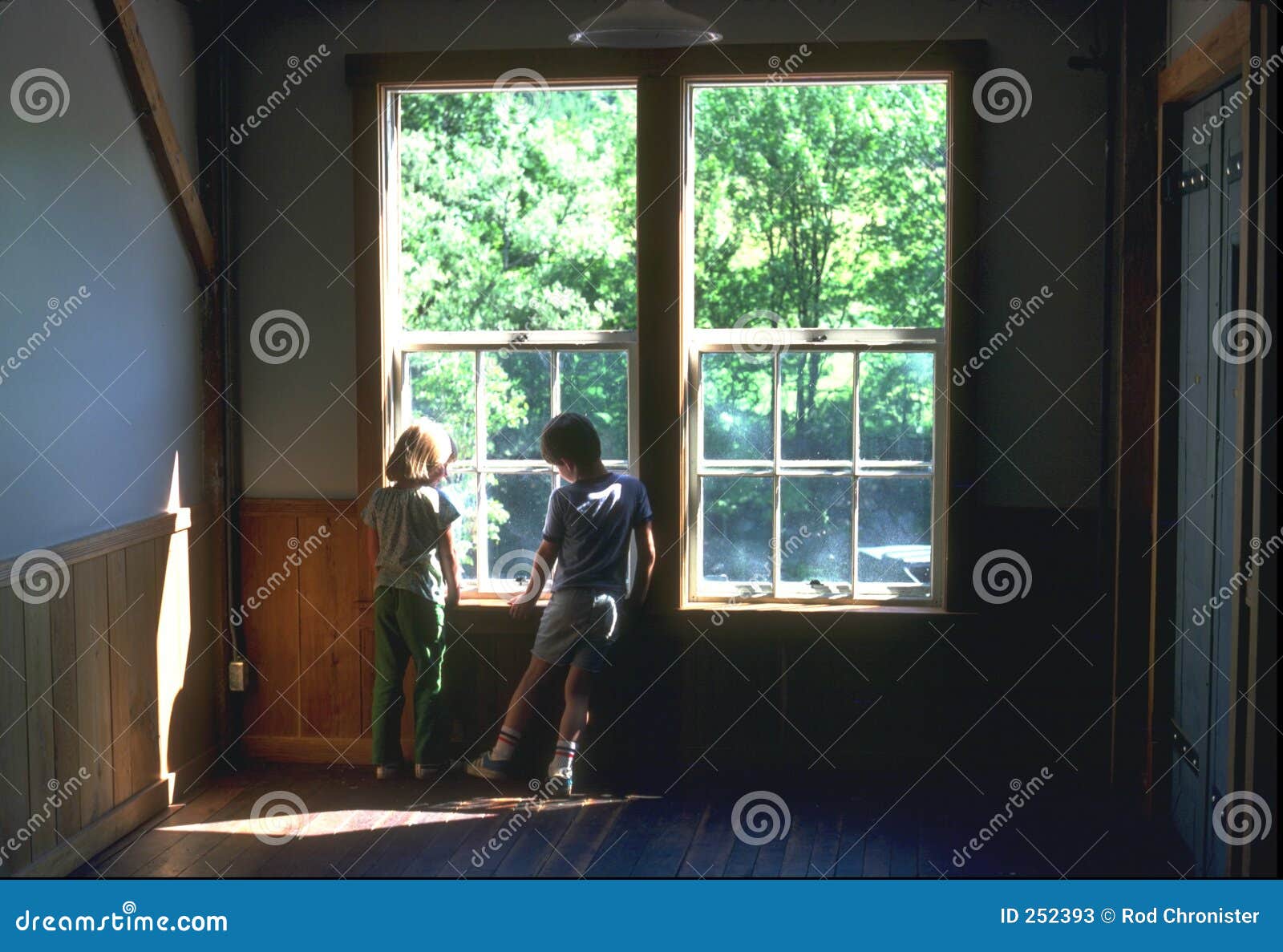 Hangin hacia fuera. Muchacho y muchacha jovenes en la ventana