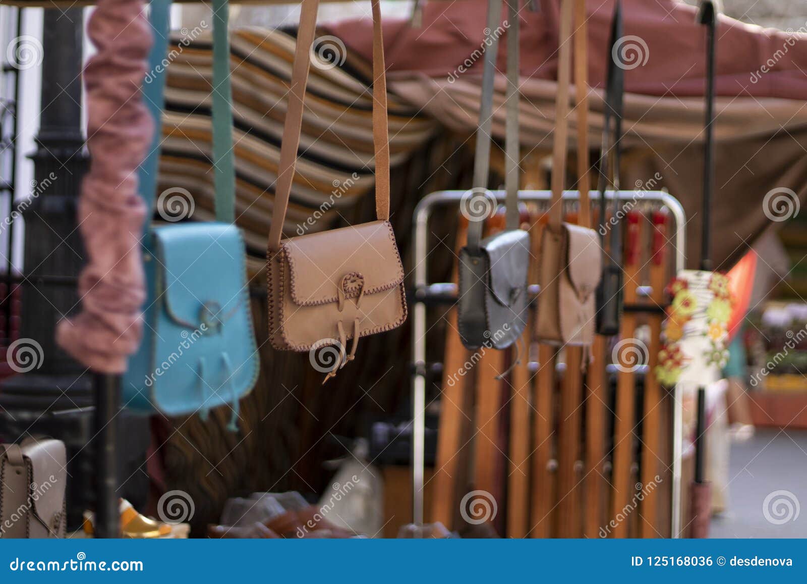 hanging handbags in a row on a street market