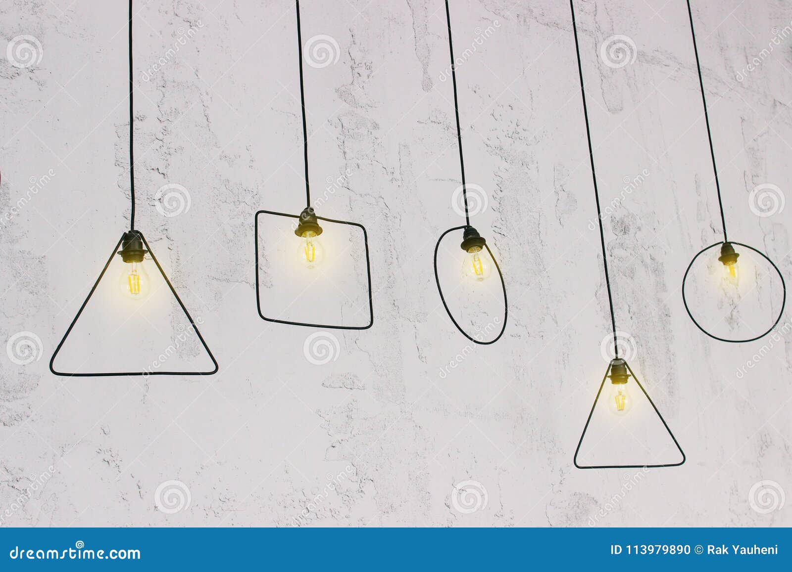 Hanging Light Bulb Near the Wall. Original Light Bulbs Stock Photo