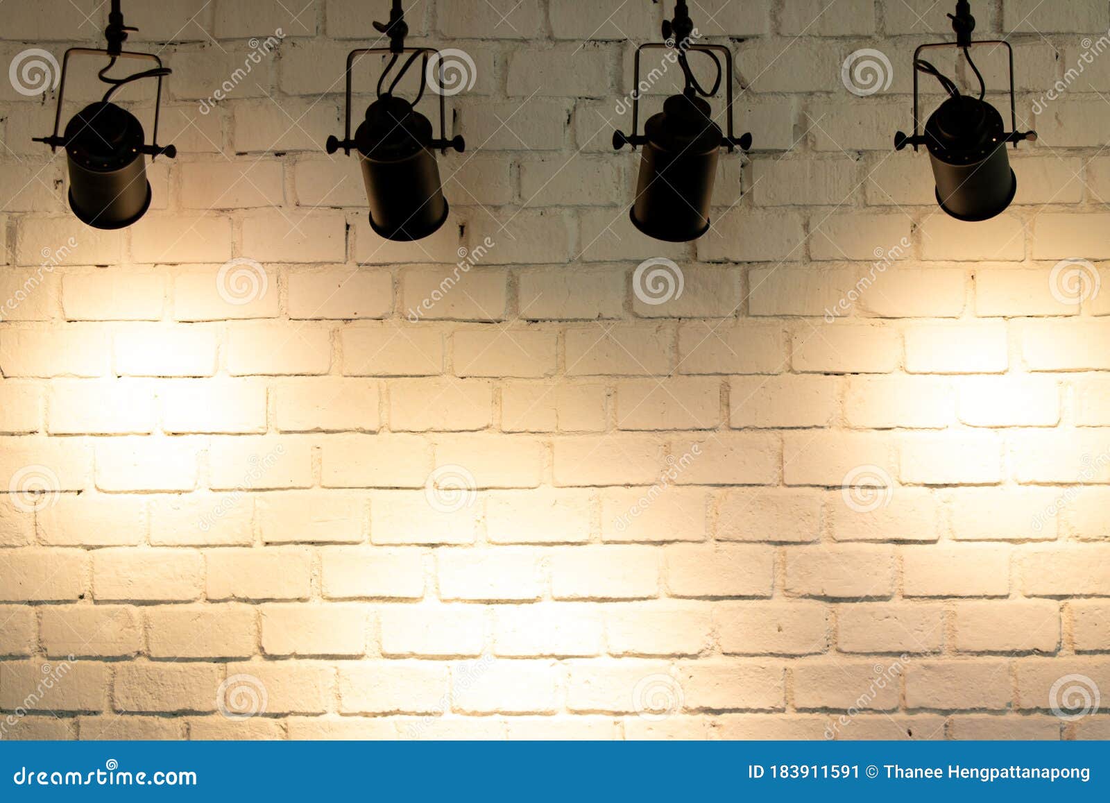 Hanging Spotlight Illuminate at Brick Wall Background Stock Image
