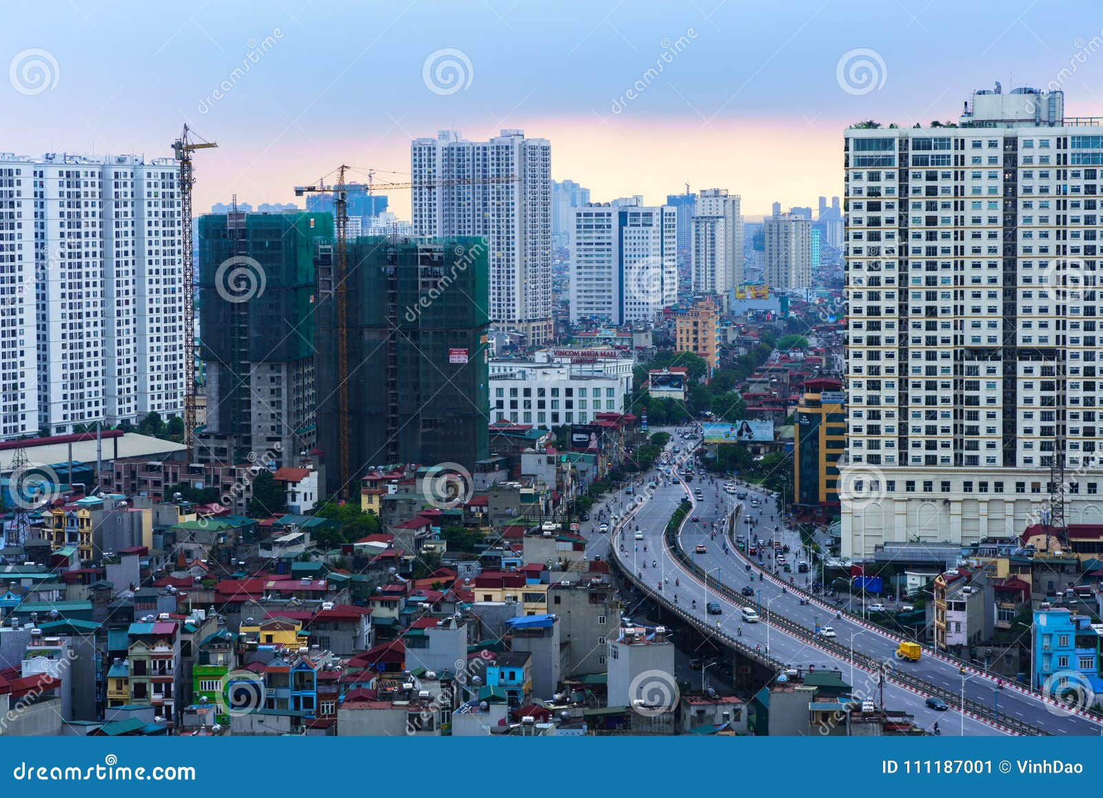 Hanoi, Vietnam - Juni 5, 2017: Luchthorizonmening van cityscape van Hanoi door schemeringperiode, met Minh Khai-straat aan de brug van Vinh Tuy, Hai Ba Trung-district