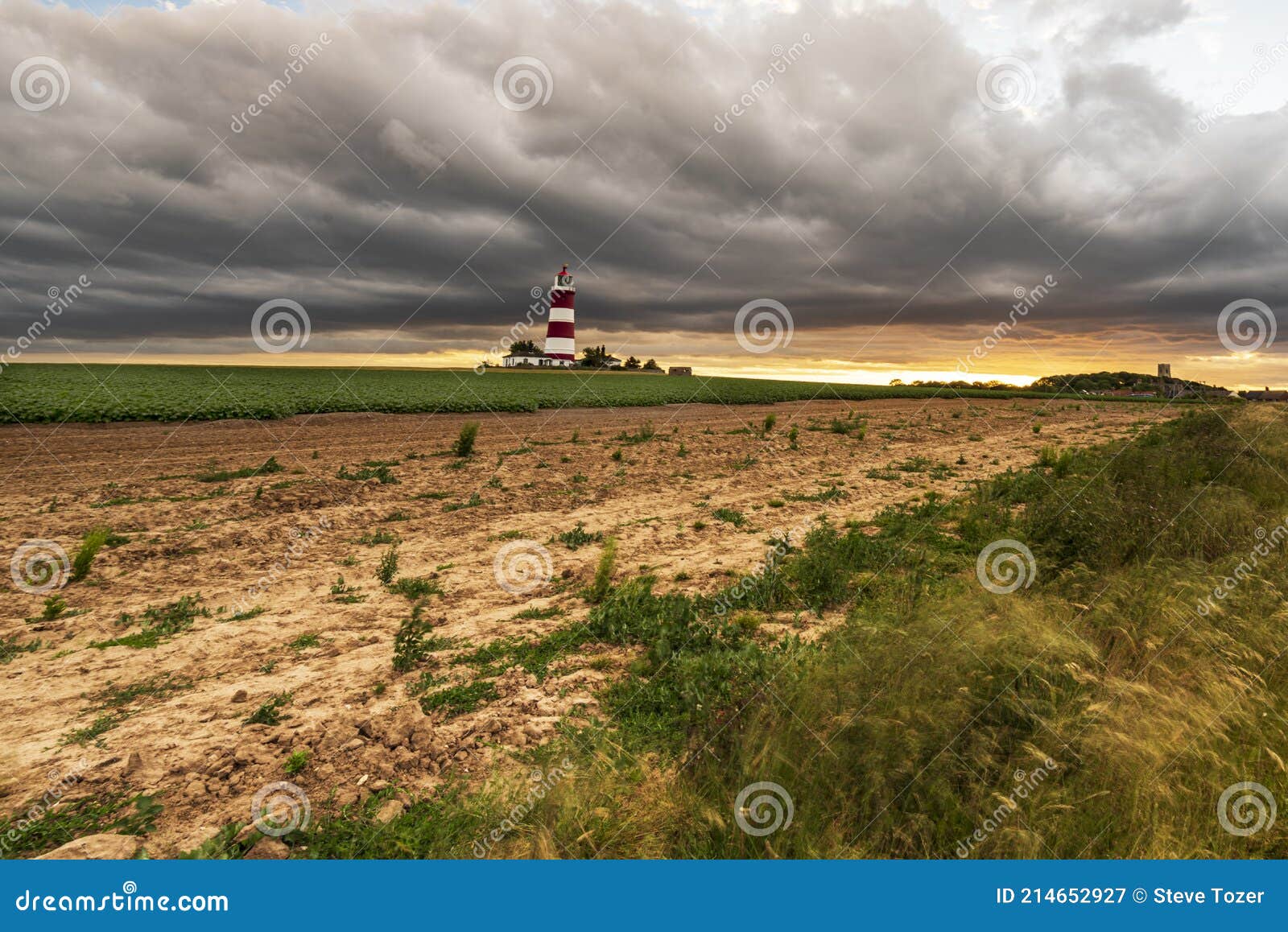 happisburgh beach lighthouse with dark stormy clouds at ssunset