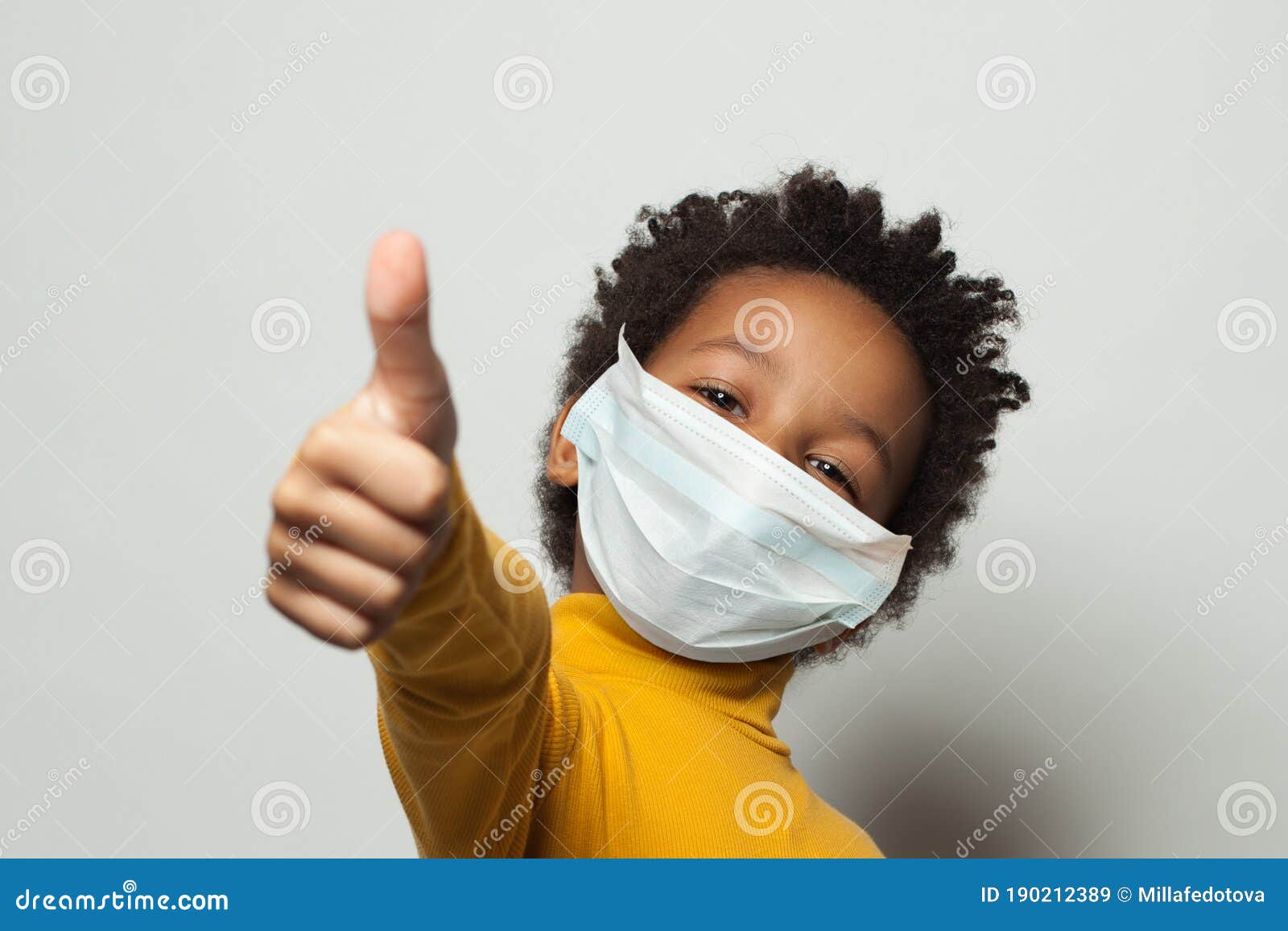 happy african american black kid in medical protective face mask showing thumb up on white