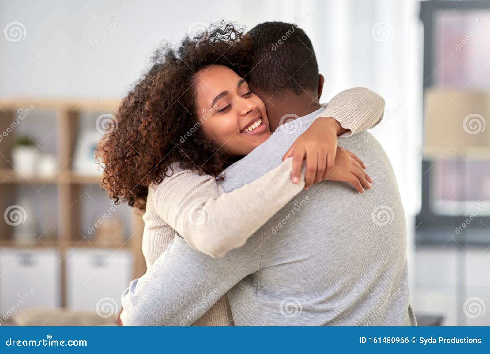 happy african american couple hugging at home