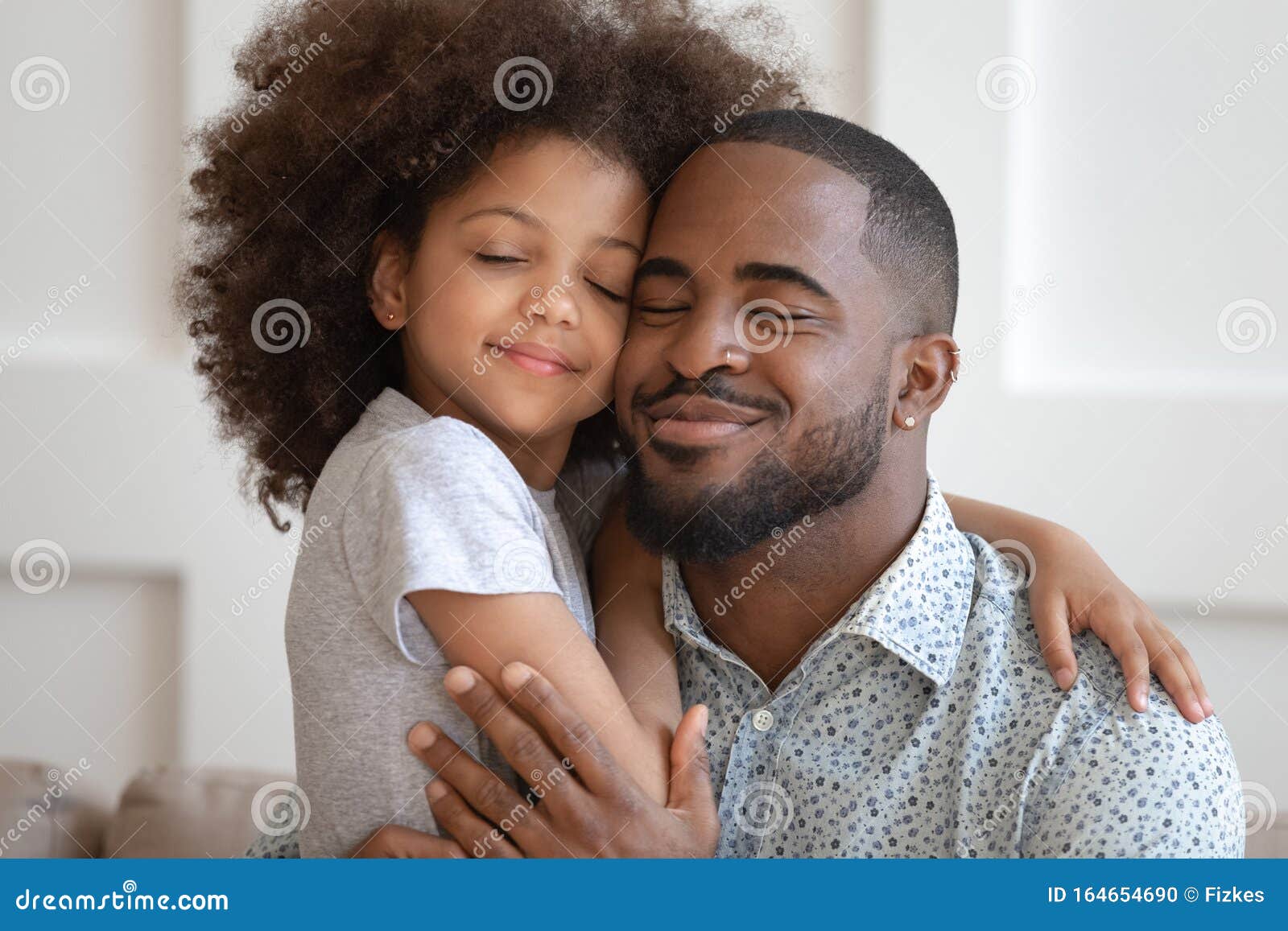 happy african american dad and daughter cuddle touching cheeks