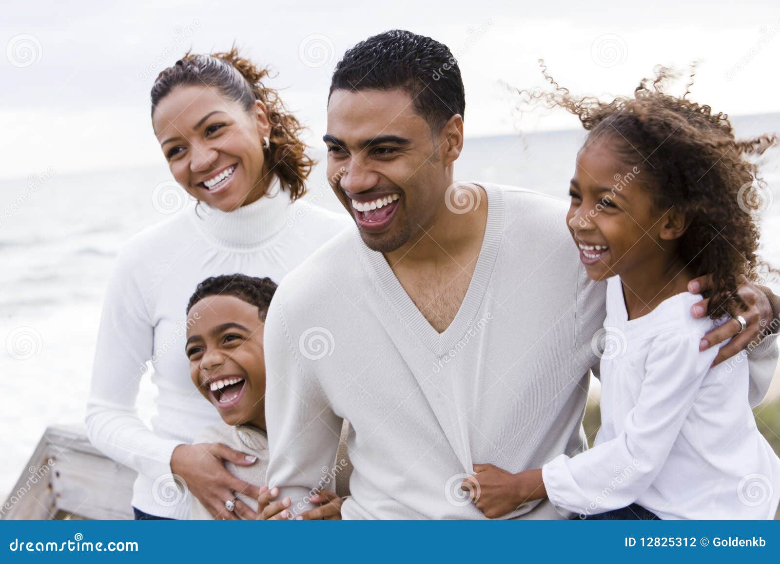happy african-american family of four on beach