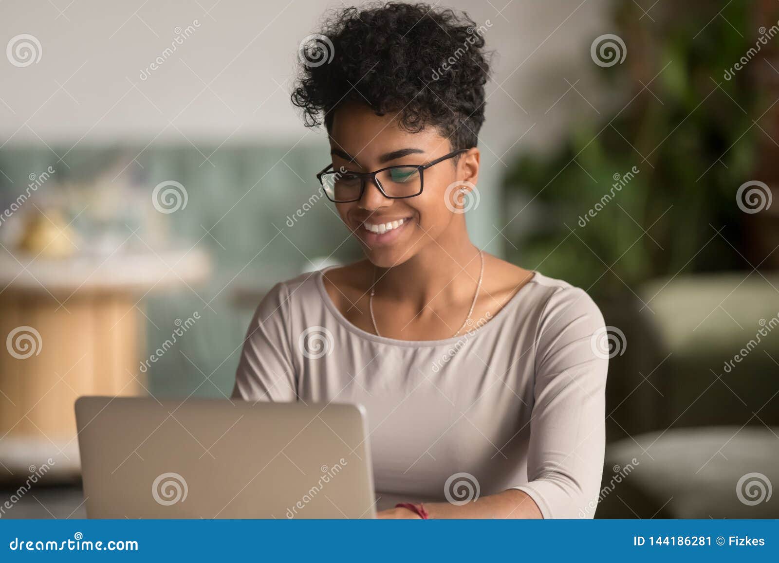 happy african american woman using laptop work study in office