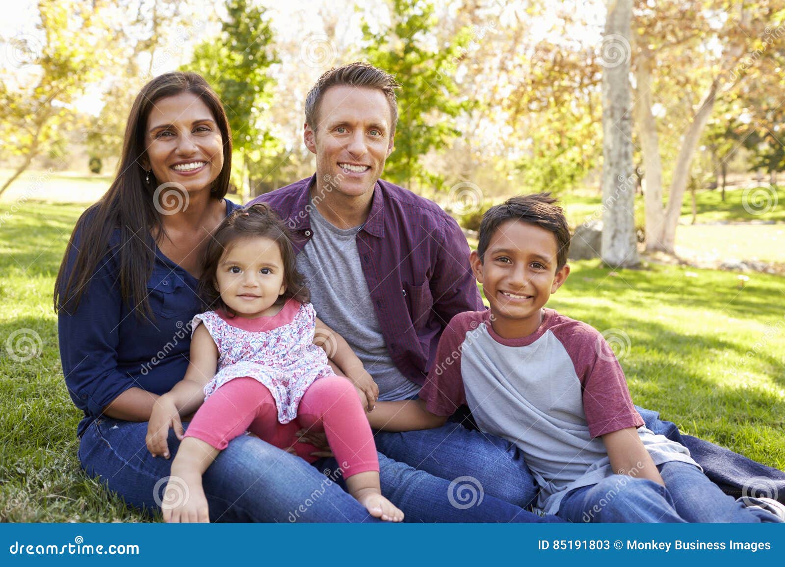 happy asian caucasian mixed race family, portrait in a park