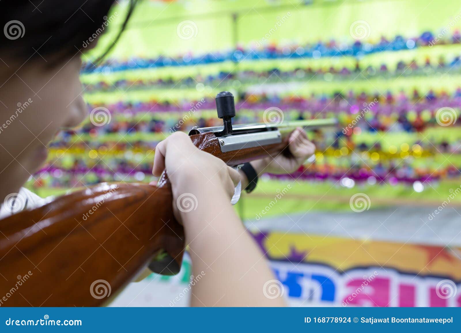 Happy Asian Child Girl Holding Wooden Gun,aim To the Point,shooting the Target,female Playing Shooting Games for a Carnival at Stock Photo