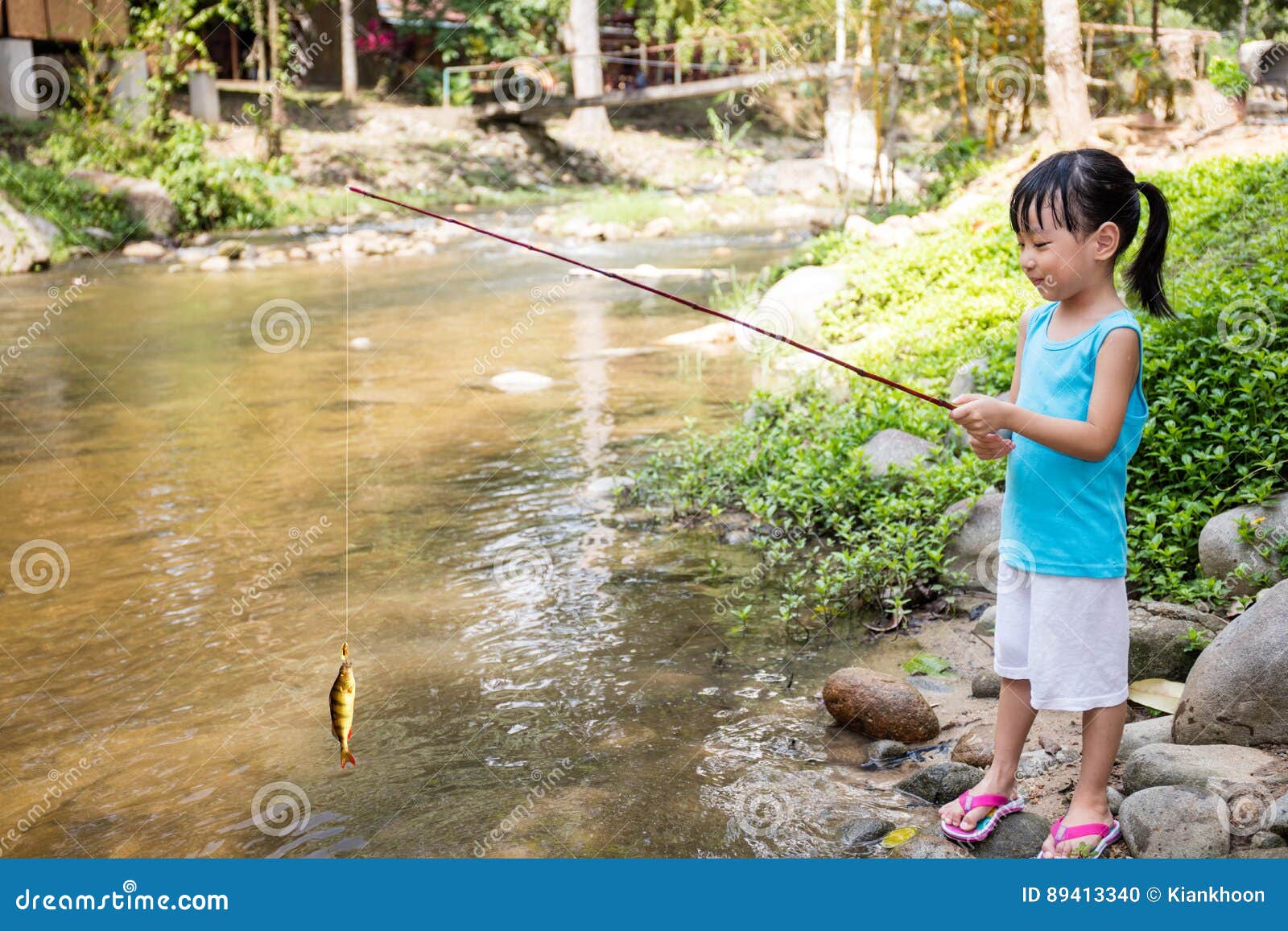 happy asian chinese little girl angling with fishing rod