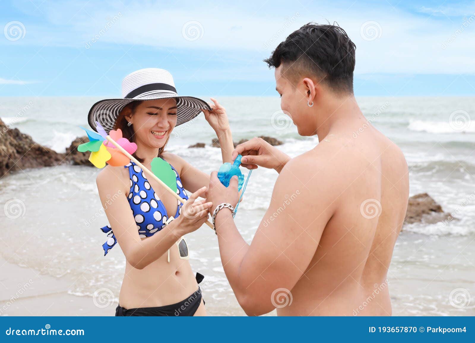 Cheerful couple having some good time naked on the beach