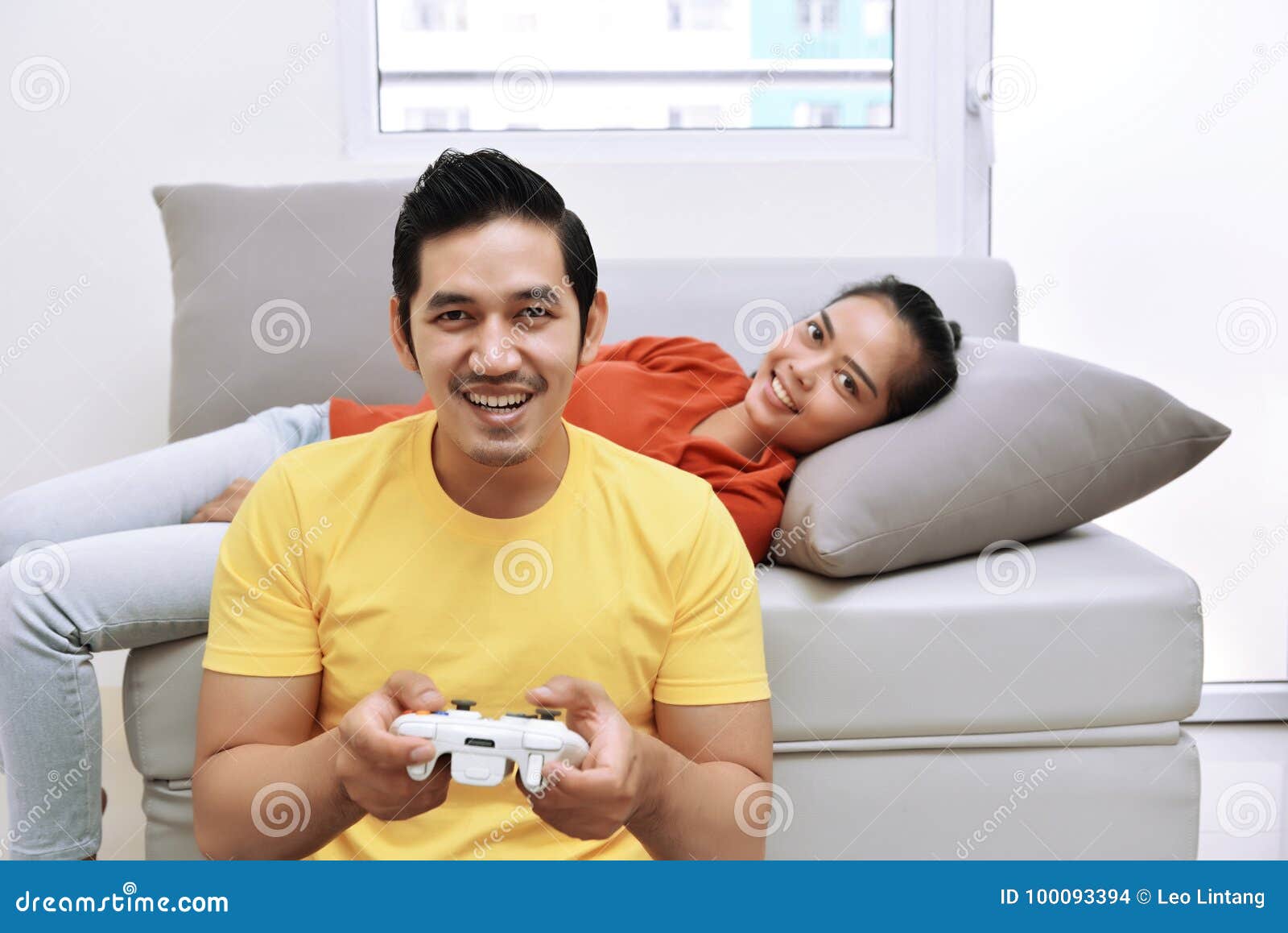 Happy Asian Couple With The Woman Lying Down On Couch And The Ma Stock ...