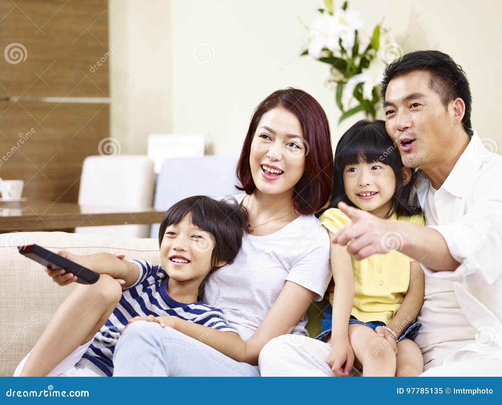 happy asian family watching tv at home