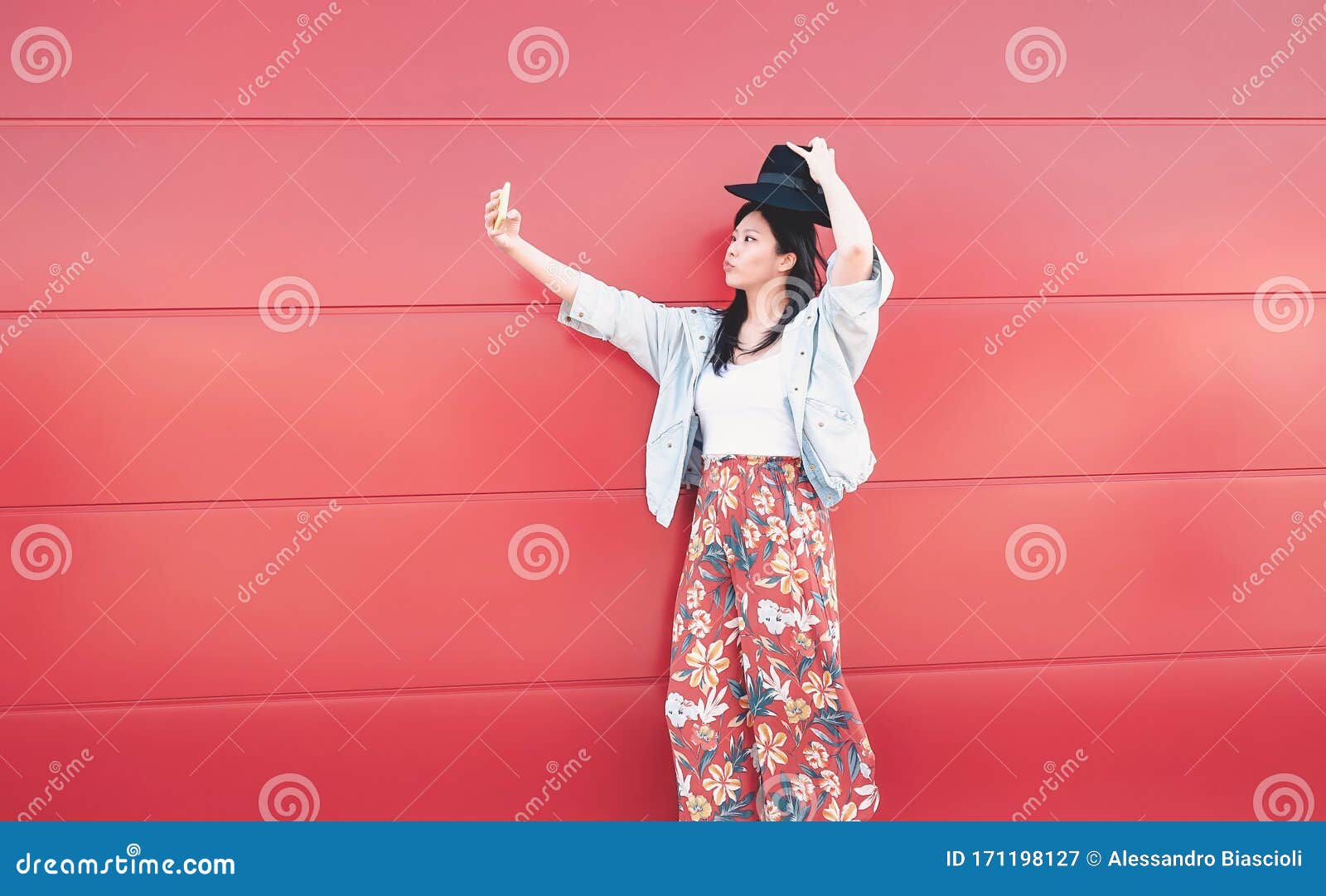 happy asian girl taking selfie with mobile phone outdoor - social influencer woman having fun with new trends smartphone apps