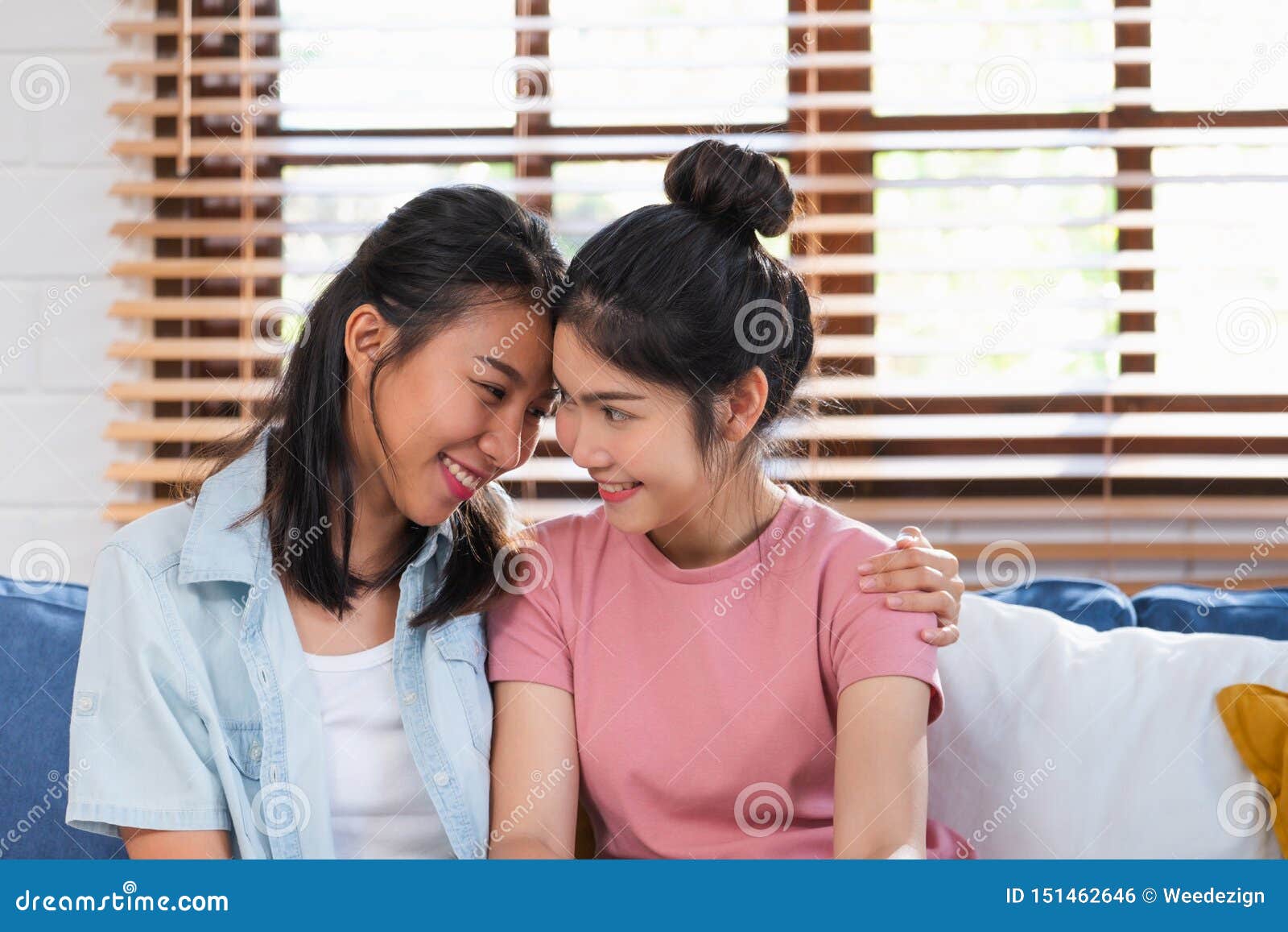 Happy Asian Lesbian Couple Hug Each Other With Love On Sofa At Living.