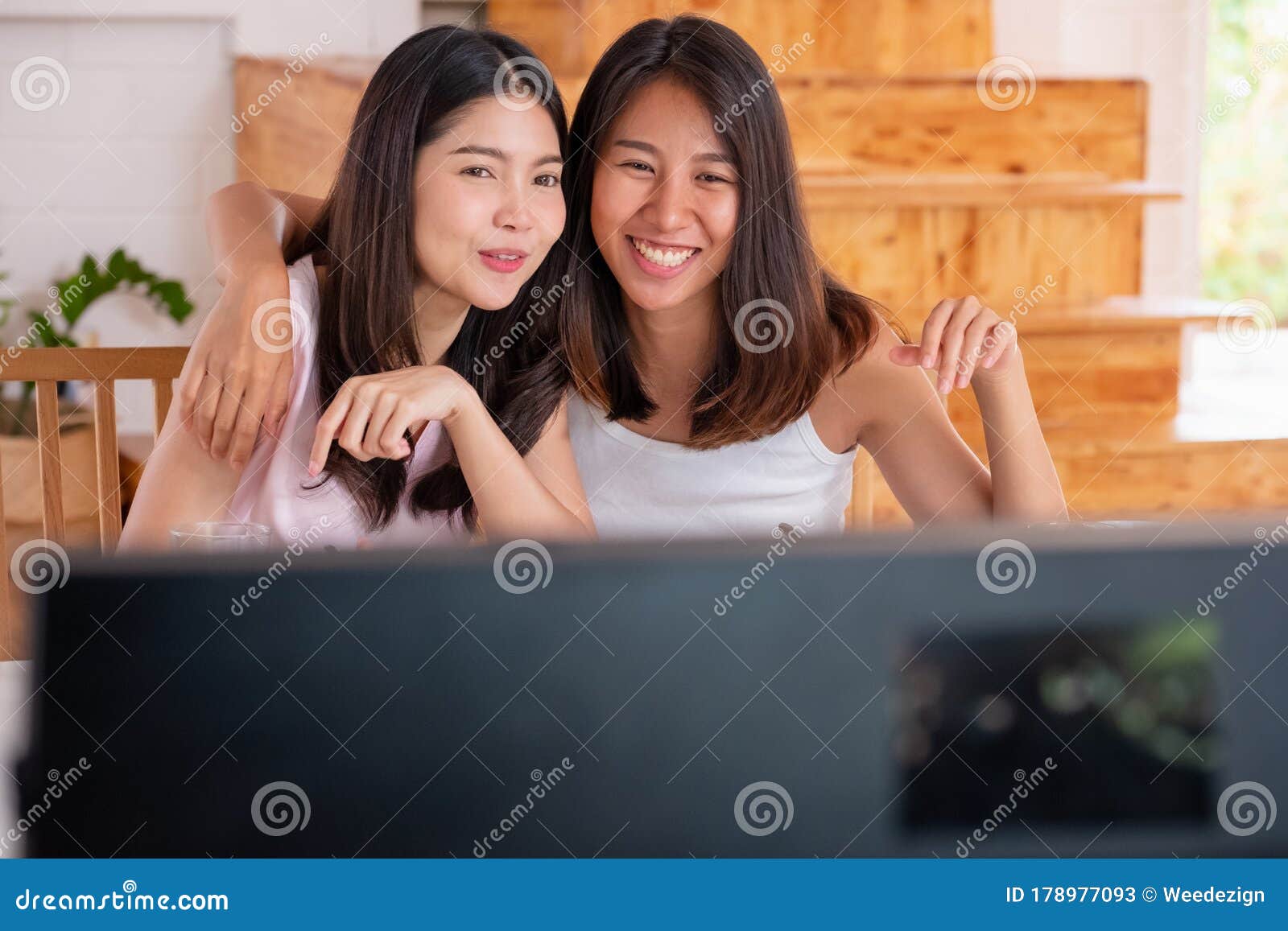 Happy Asian Lesbian Couple Watching Television While Eati