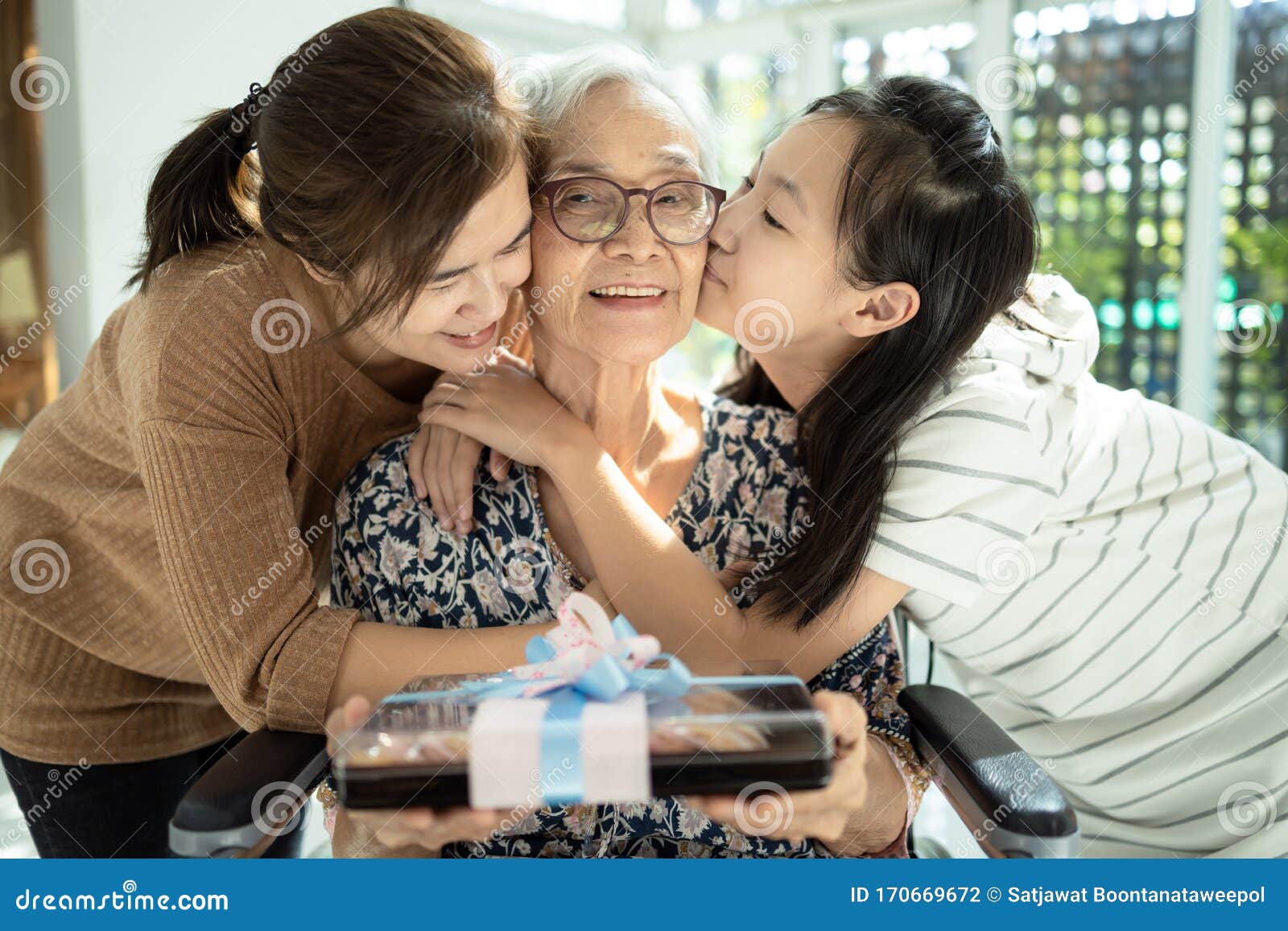 happy asian mother,daughter meeting old grandparent,giving grandmother a gift,hugging,female elderly hold  present box,woman,child