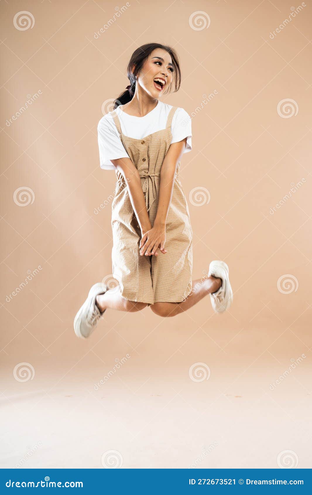 happy asian woman in casual clothes with poni tail jumping