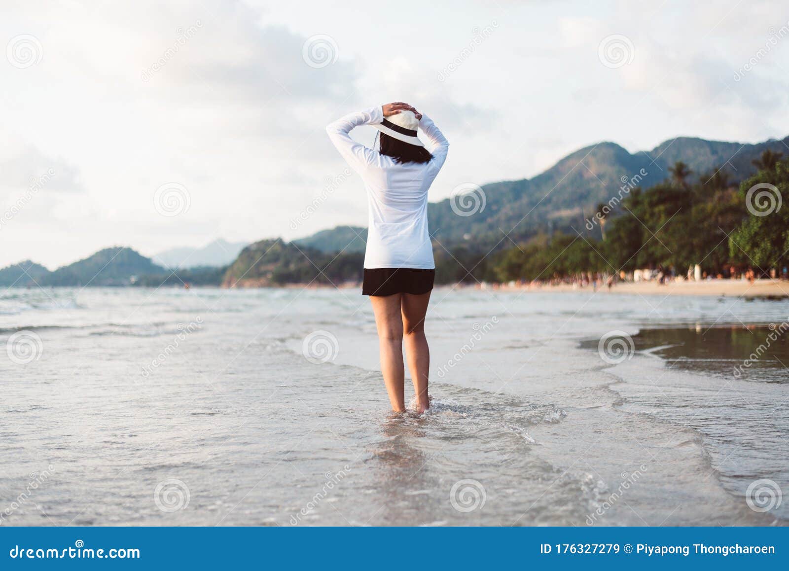 Happy Asian Woman Walking On The Beach Near Sea While Beautiful Sunrise 