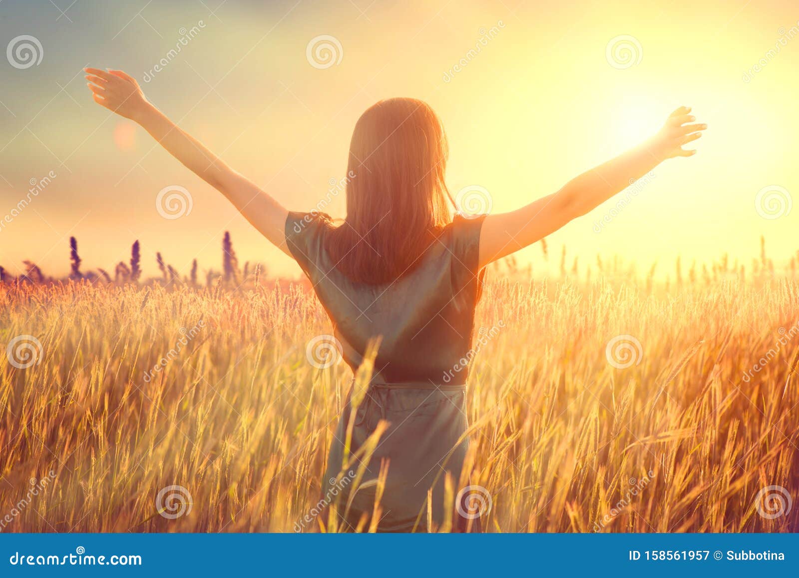 happy autumn woman raising hands over sunset sky, enjoying life and nature. beauty female on field looking on sun