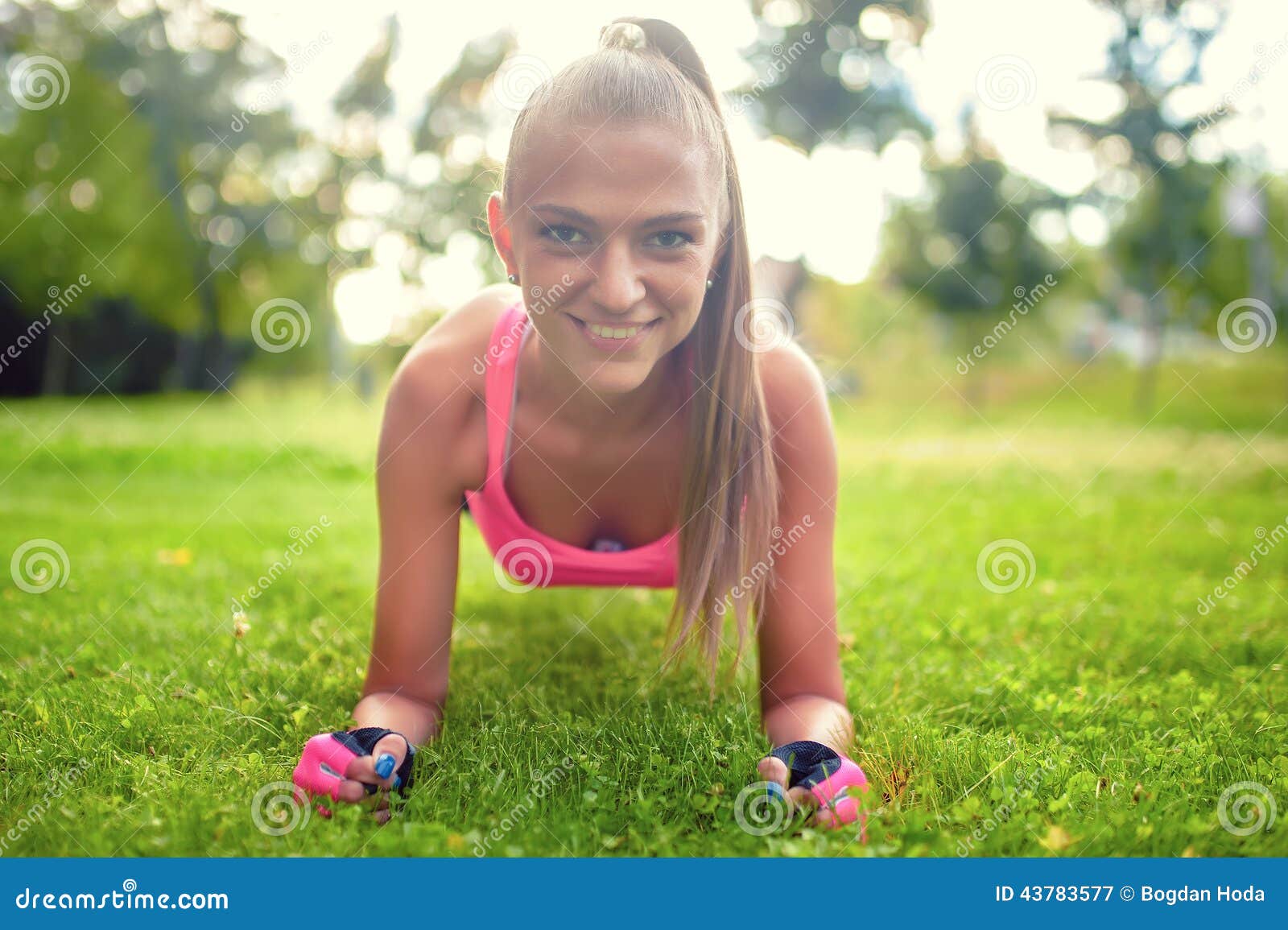 happy, beautiful blonde girl doing abs and isometry on grass