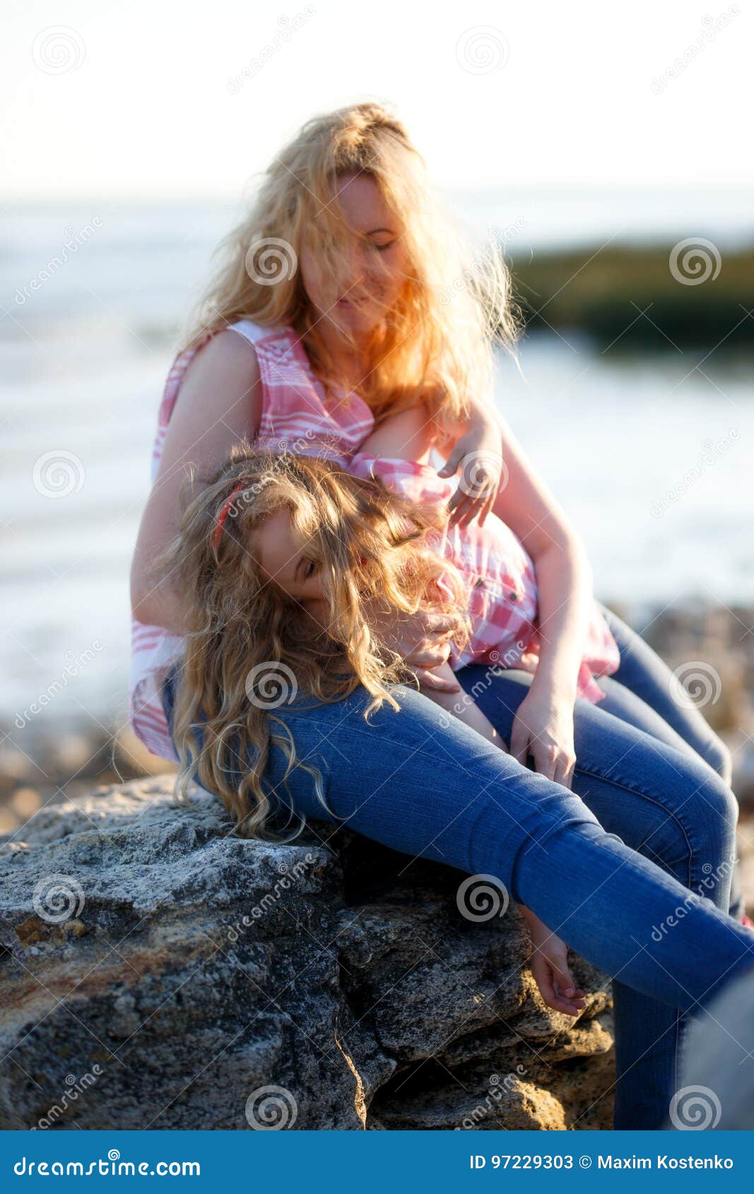 Happy Beautiful Mother And Her Daughter Having Fun On The Rocky Beach At Sunset Stock Image 