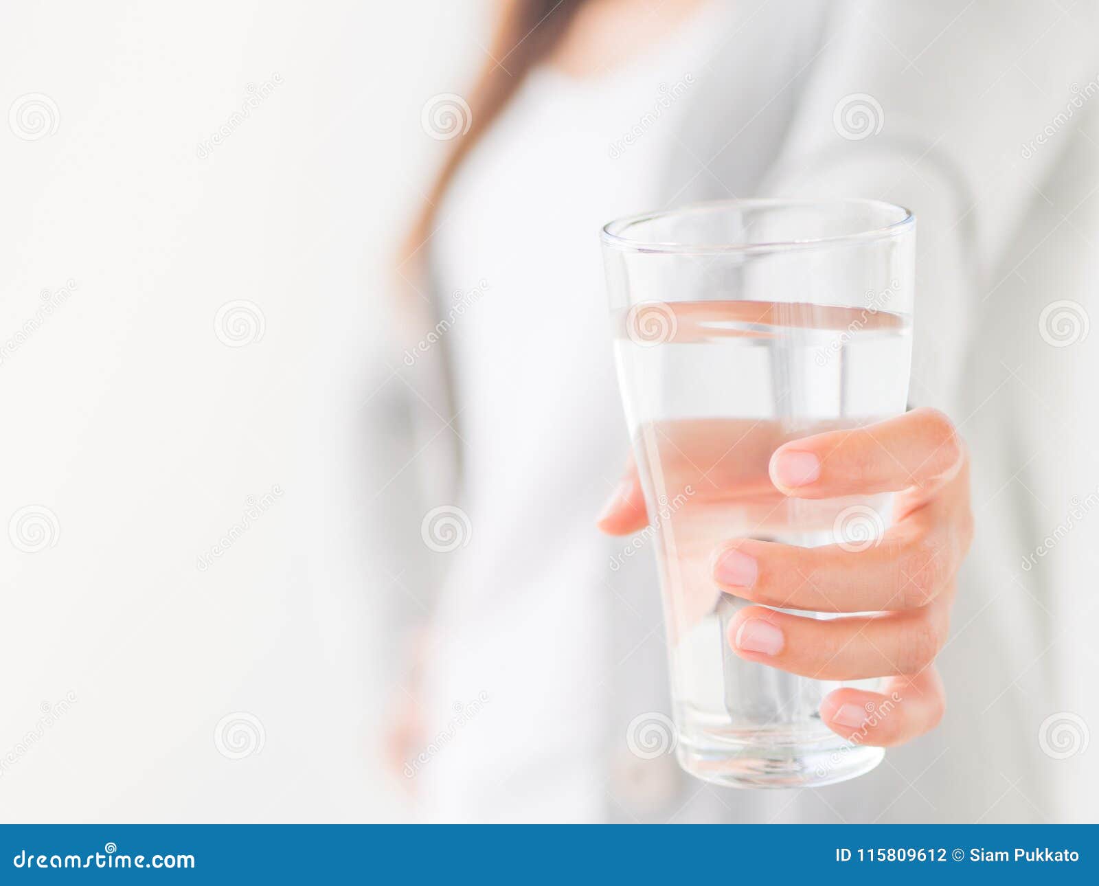 A person holding a glass of water in front of a window · Free Stock Photo