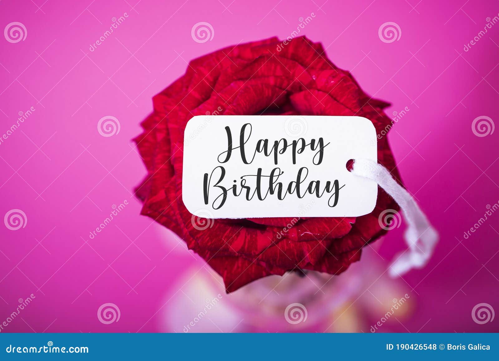 happy birthday written on a white banner with flowery background. image in pastel colors and selective focus